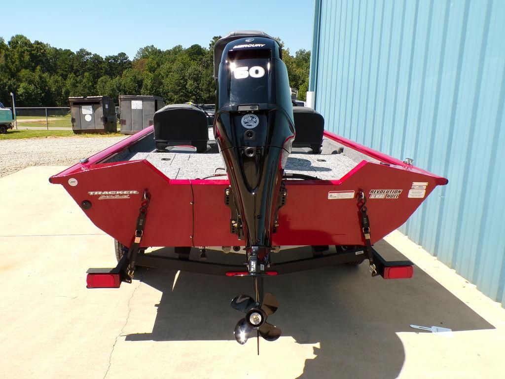 2025 Tracker Pro Team 175 TF® boat, red, with a 50 HP outboard motor, parked outdoors.