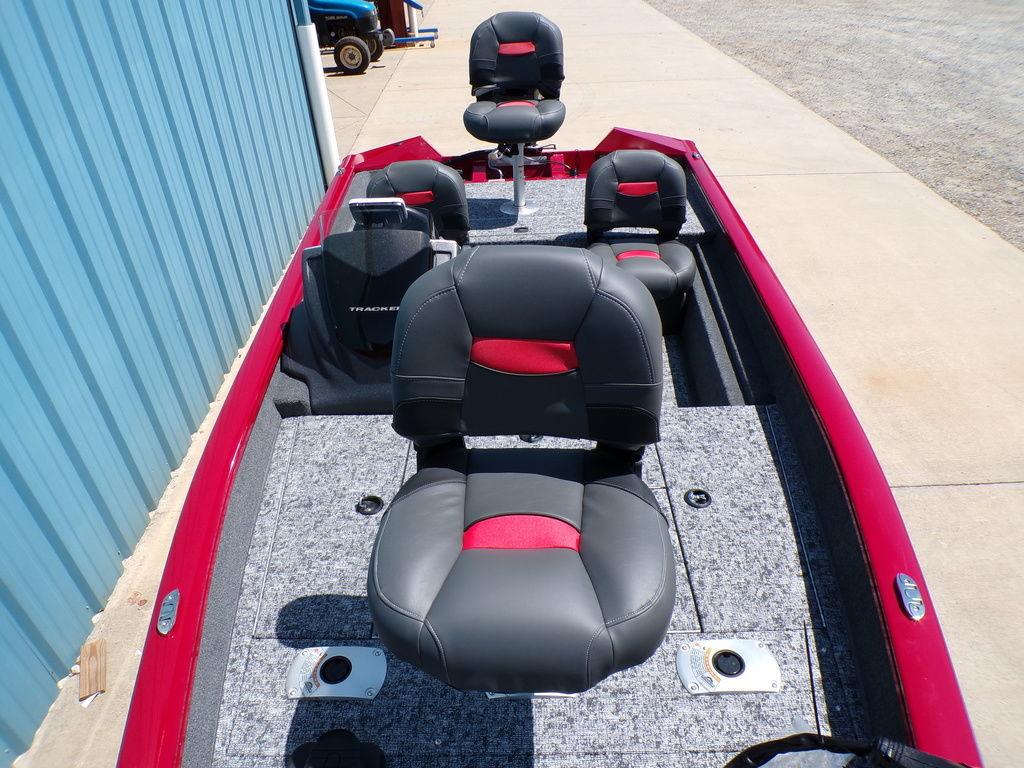 2025 Tracker Pro Team 175 TF® boat with red and black seating, docked near a blue building.