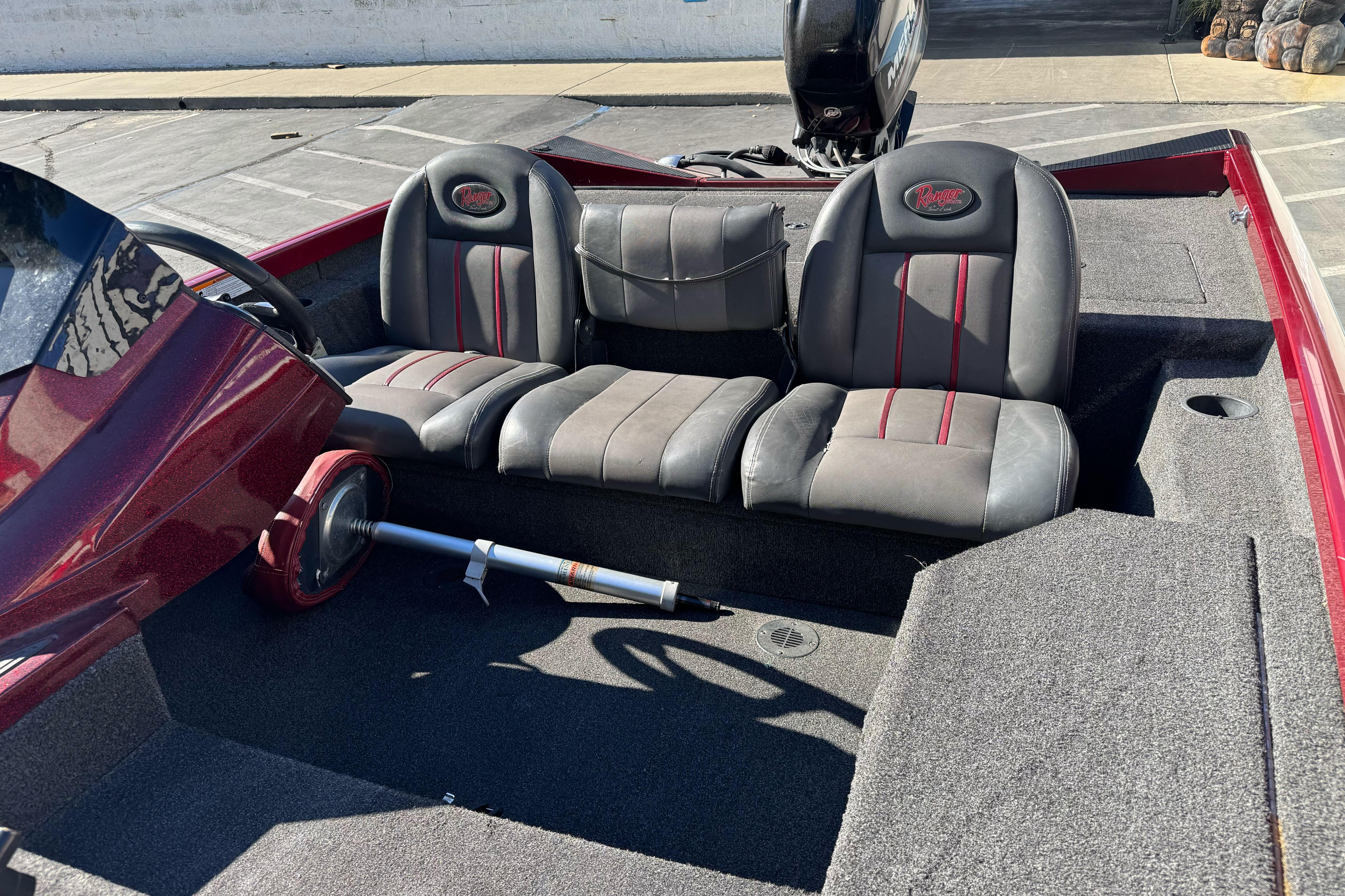 2016 Ranger RT178 boat interior with gray and red seats, steering wheel, and carpeted flooring.