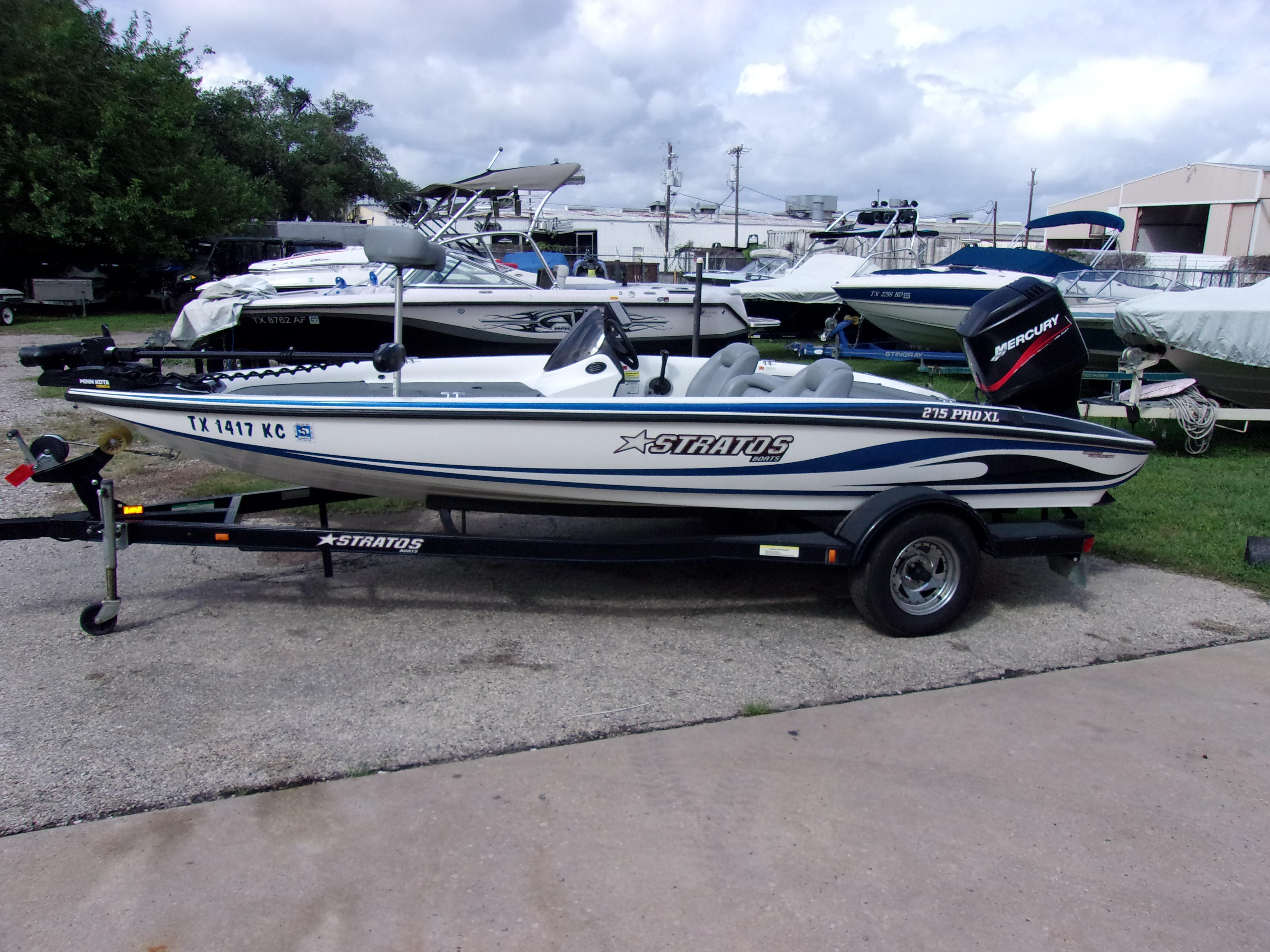 2004 Stratos 275 Pro XL boat on trailer, parked outdoors with other boats.