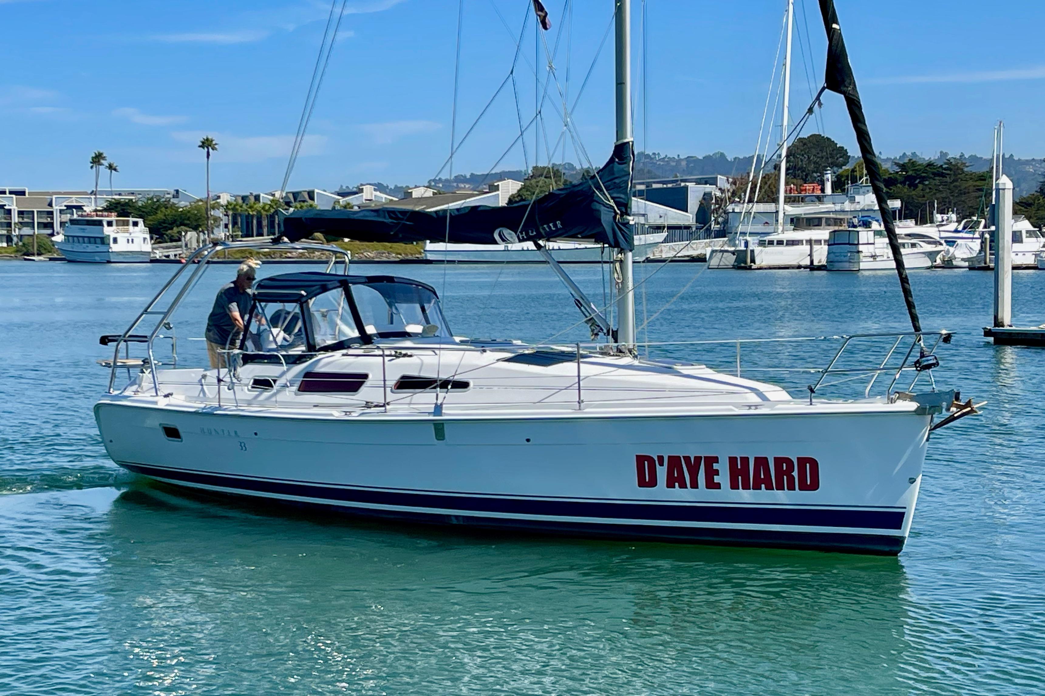 Sailboat "D'AYE HARD," Hunter 33-2, 2004 model, cruising in a marina.