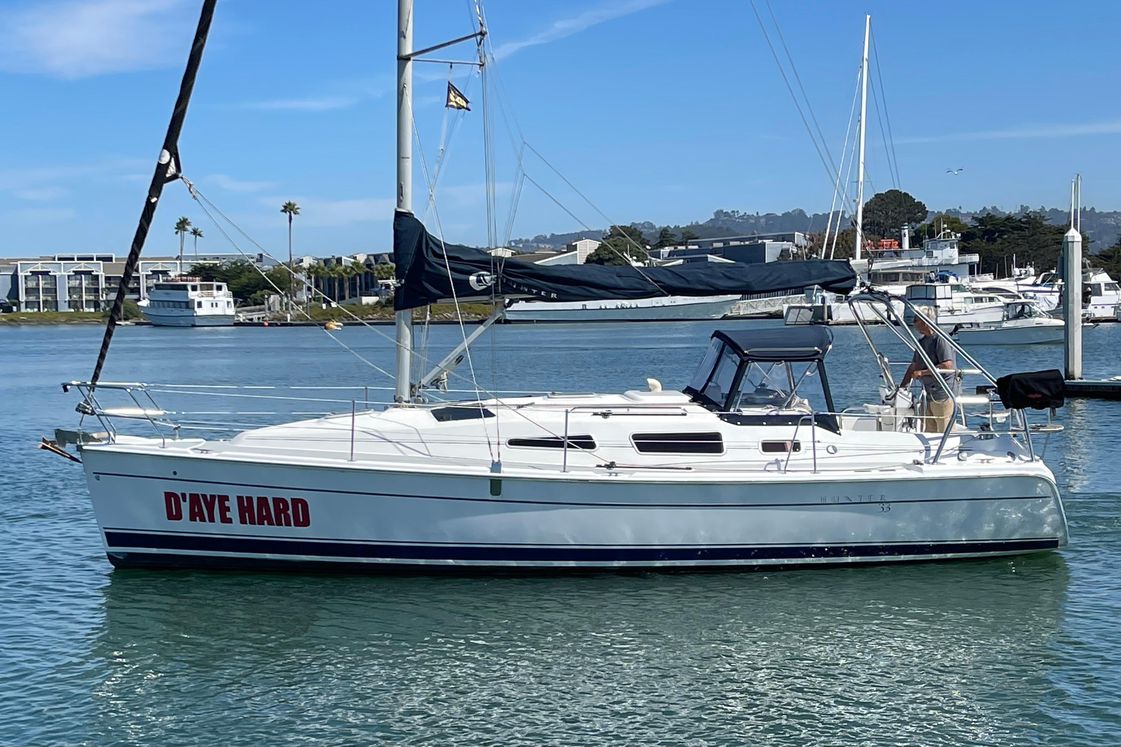 2004 Hunter 33-2 sailboat named "D'AYE HARD" docked in a marina.