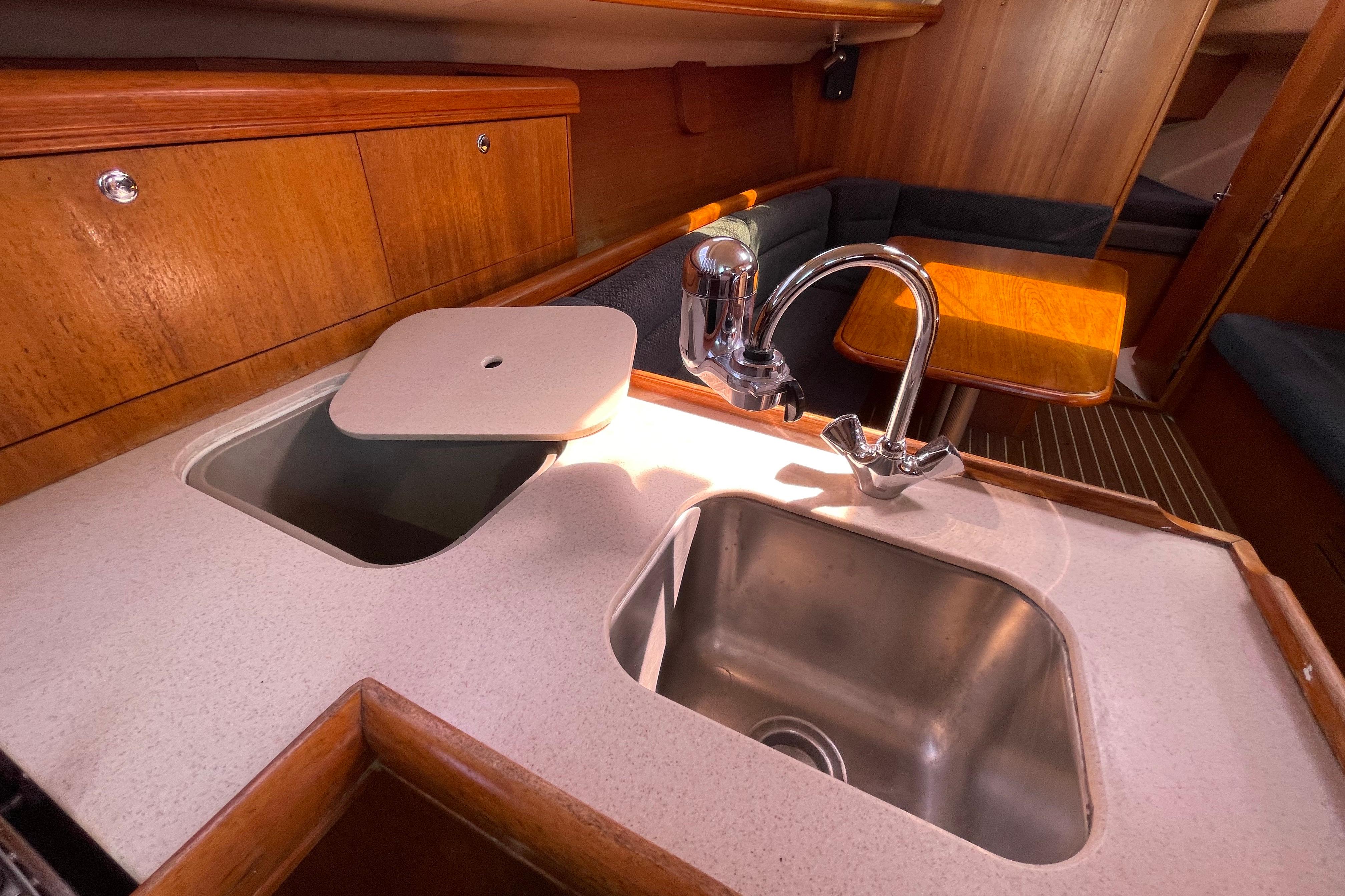 Hunter 33-2 yacht interior, 2004 model, featuring a compact kitchen sink and wooden cabinetry.