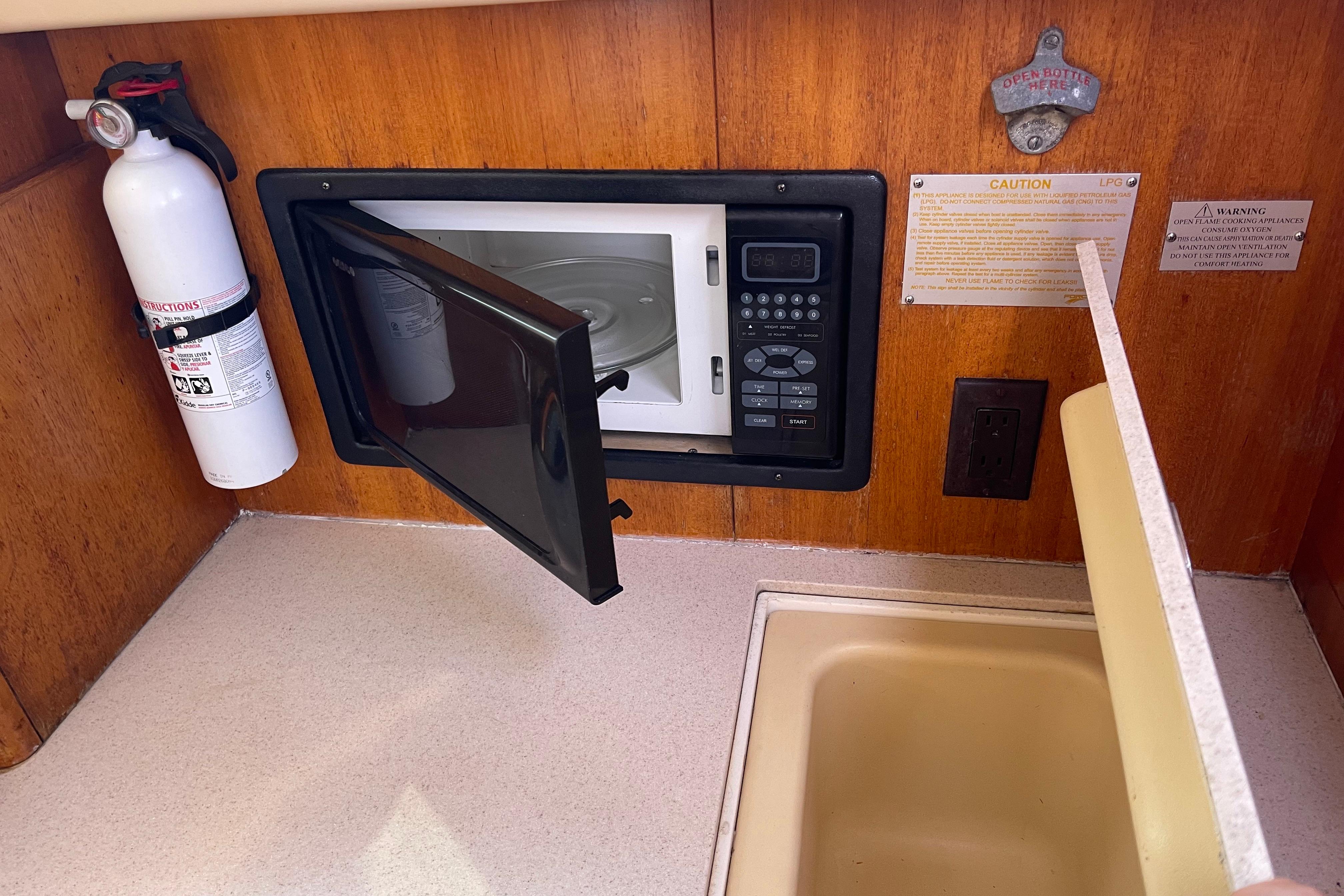 2004 Hunter 33-2 yacht kitchen with microwave, fire extinguisher, and sink.