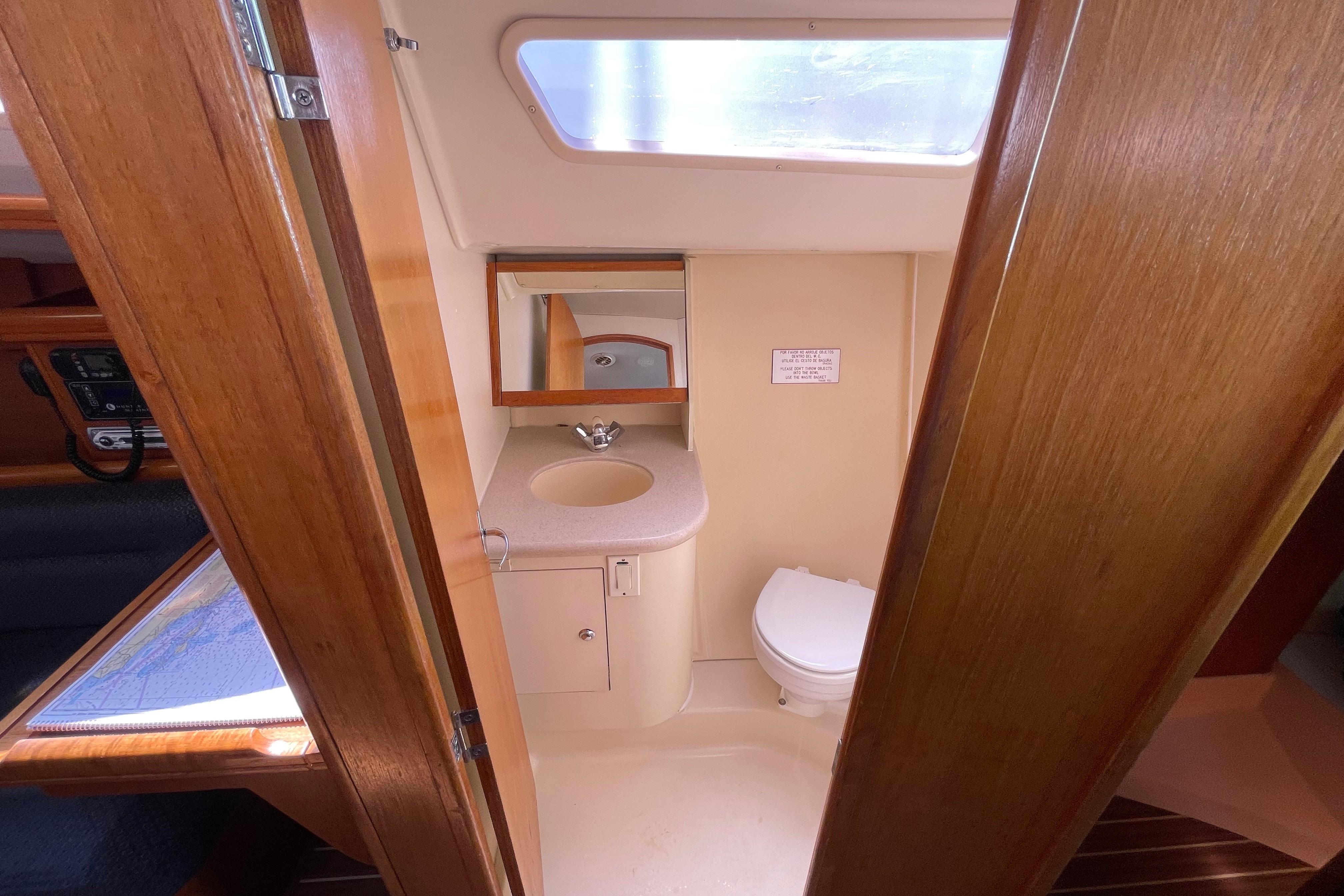 2004 Hunter 33-2 yacht bathroom with sink, mirror, and toilet.