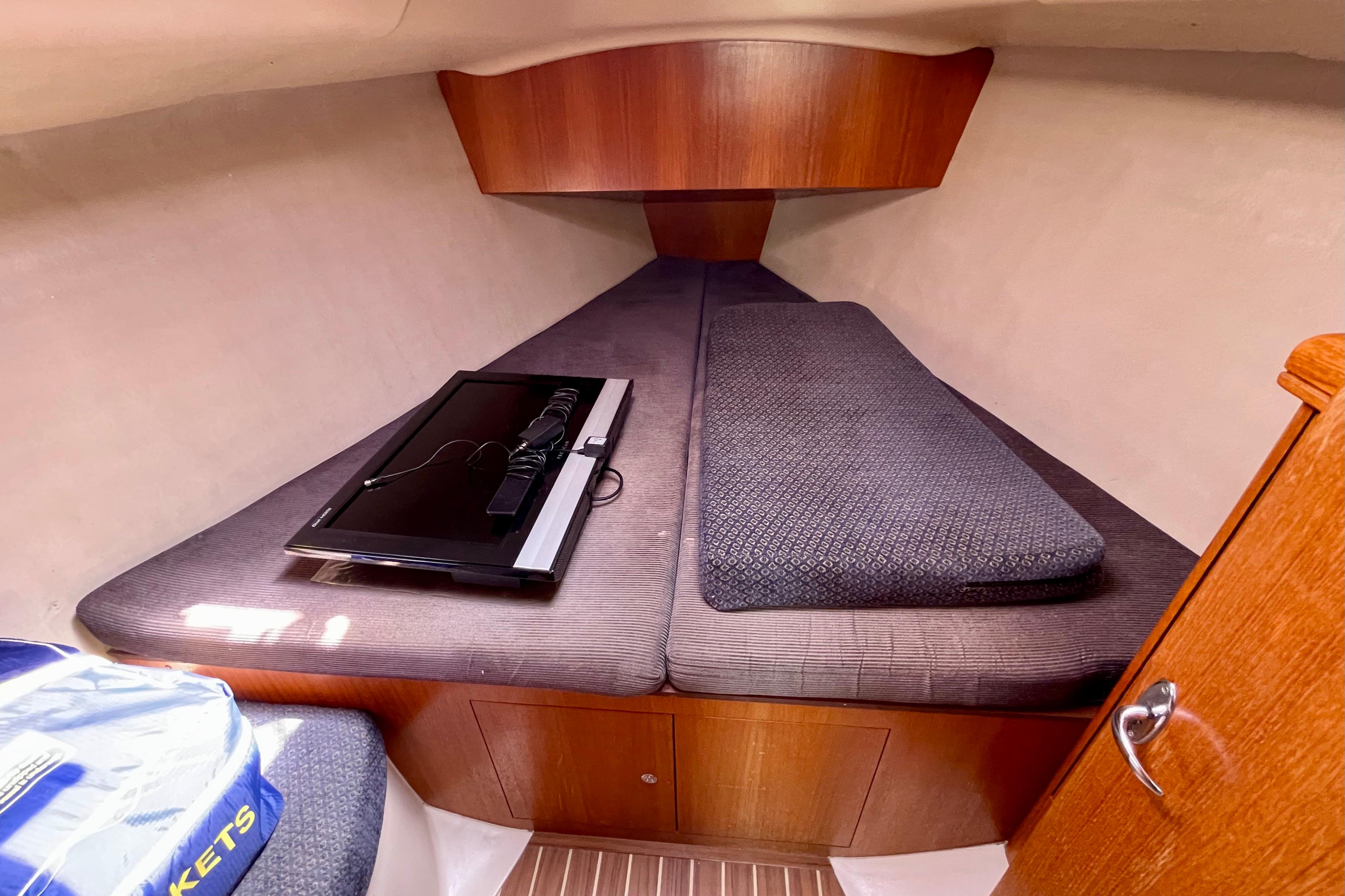 2004 Hunter 33-2 sailboat interior cabin with cozy bedding and wooden accents.