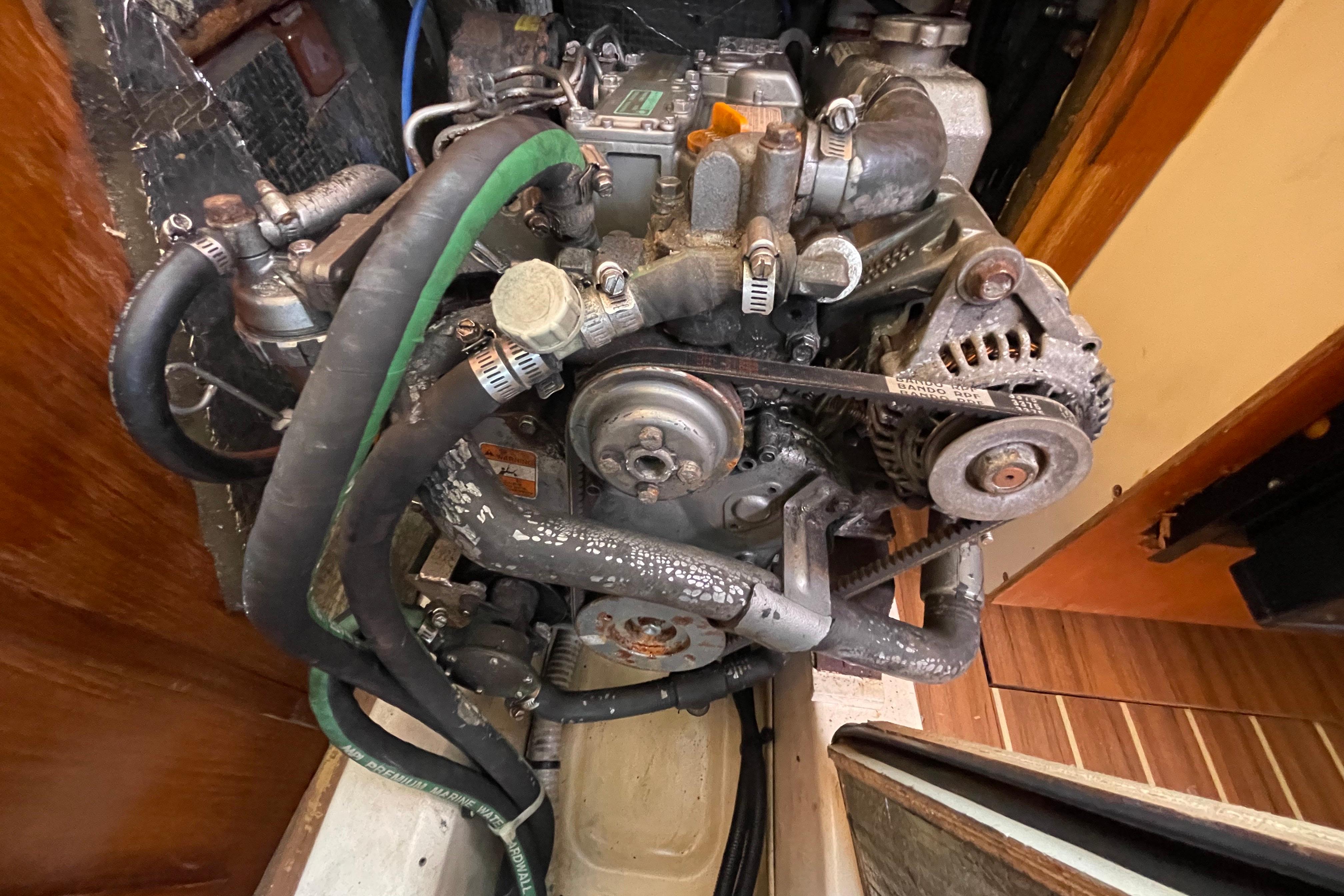 2004 Hunter 33-2 engine with visible belts and hoses in a wooden compartment.