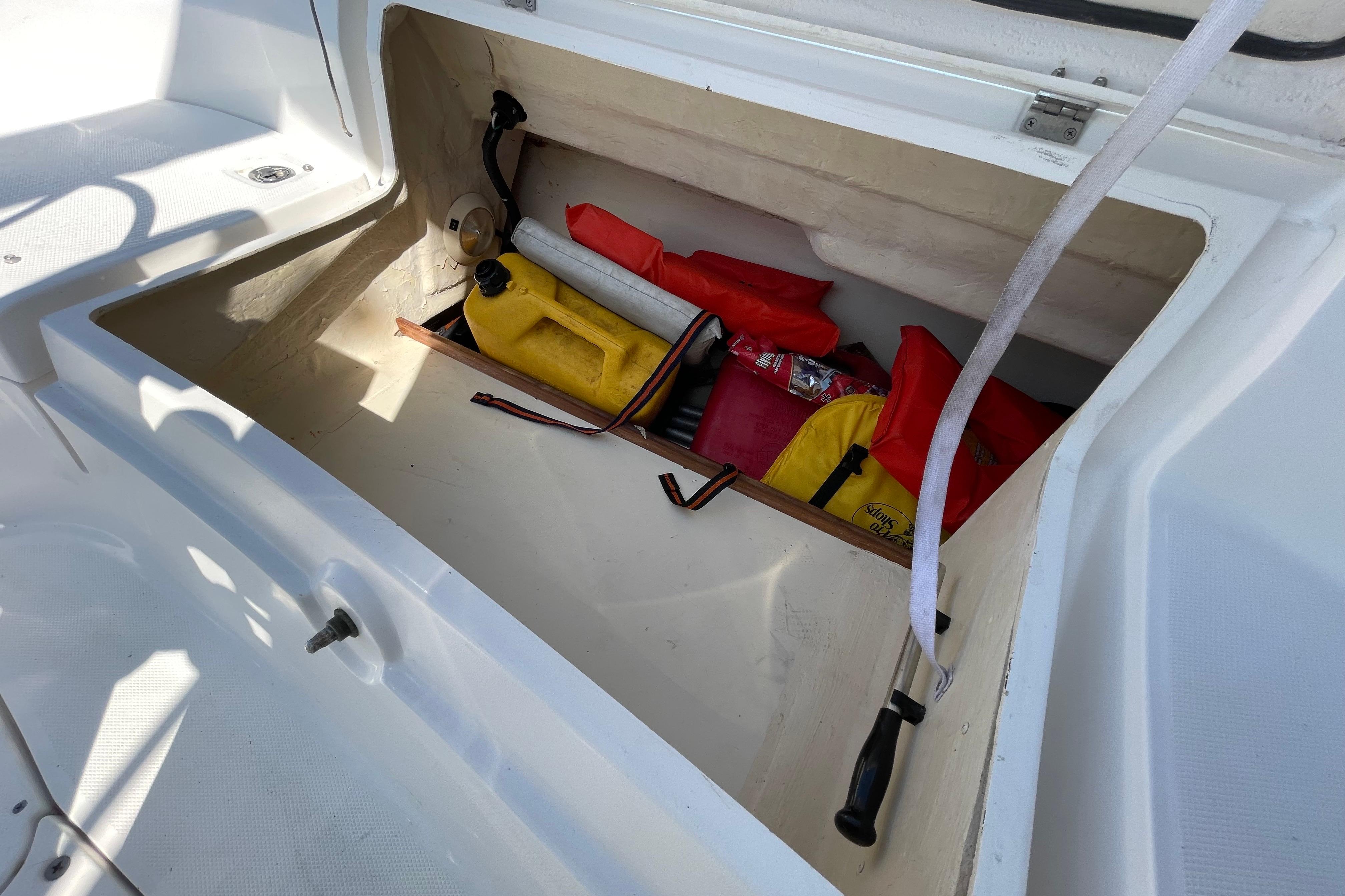 Storage compartment of a 2004 Hunter 33-2 boat with safety gear and equipment.
