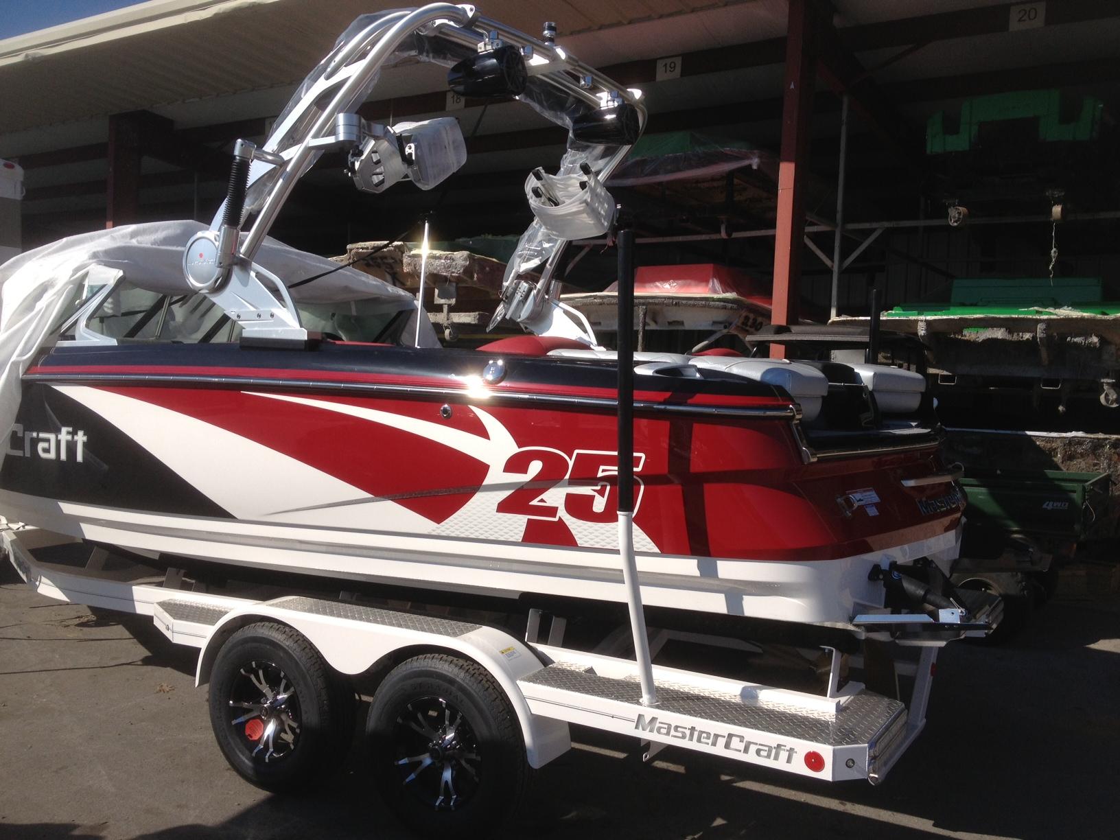 2013 MasterCraft X-25 boat on trailer, red and white design, parked outdoors.