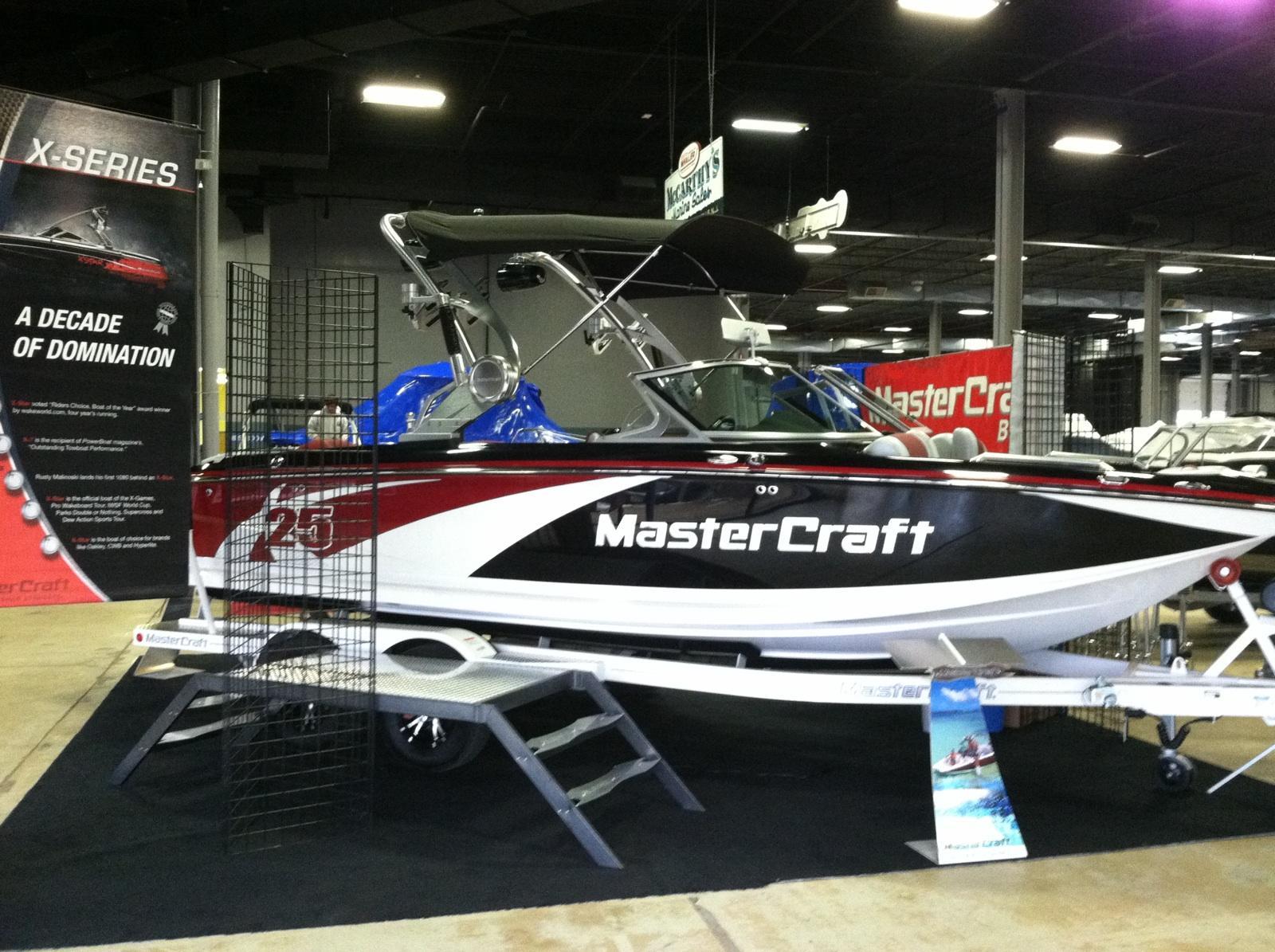 2013 MasterCraft X-25 boat displayed indoors at a boat show.