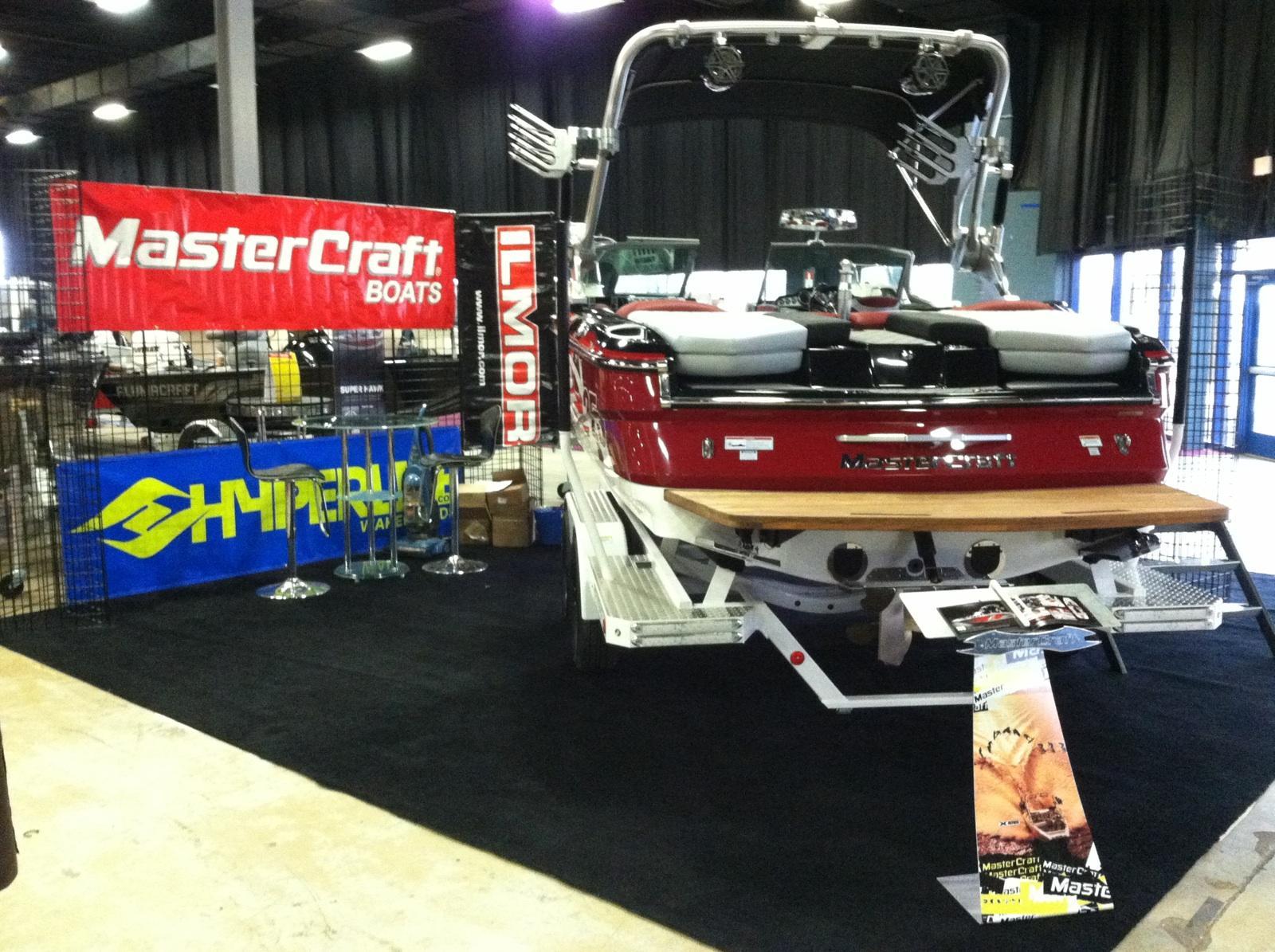 2013 MasterCraft X-25 boat displayed indoors with promotional banners and accessories.