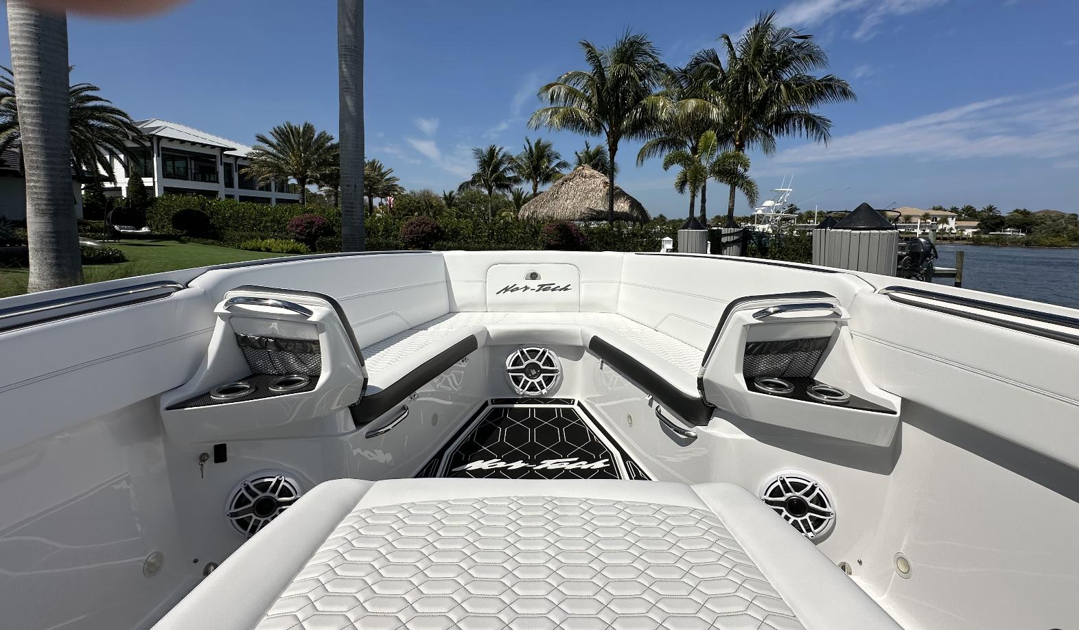 Nor-Tech-390 Sport Center Console 2023 -KY-US-2023 Nor-Tech 390 Sport Center Console boat interior with seating and speakers, surrounded by palm trees.-9746423 | Thumbnail