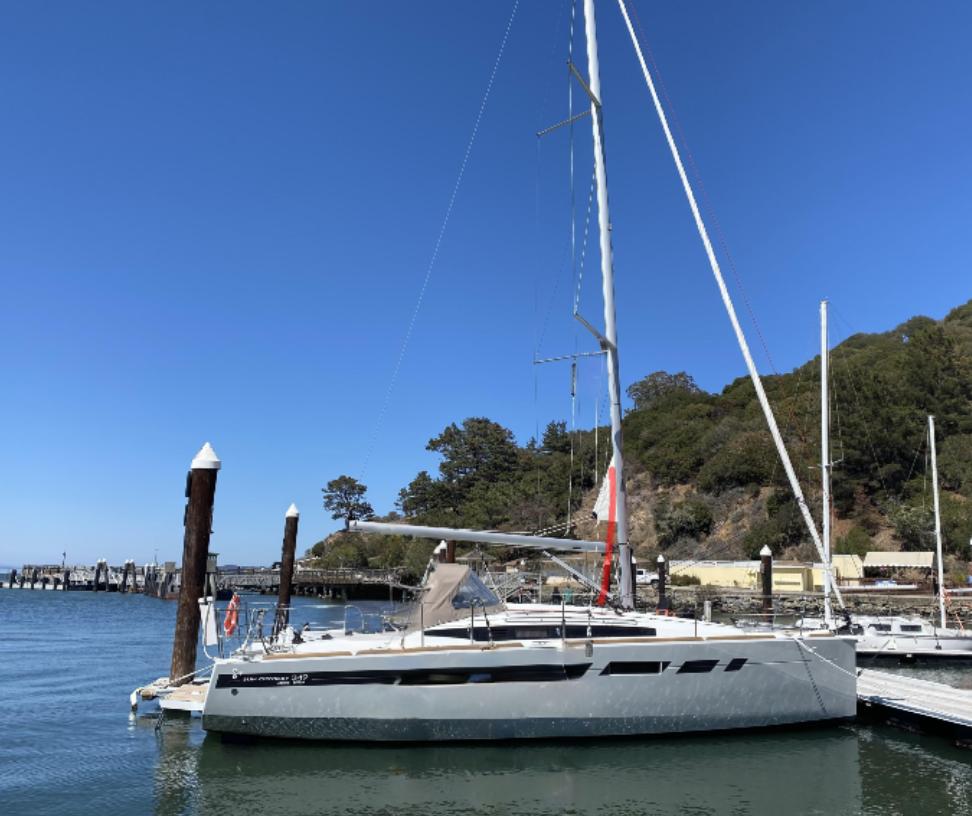 2021 Jeanneau Sun Odyssey 349 sailboat docked in a marina under clear blue skies.
