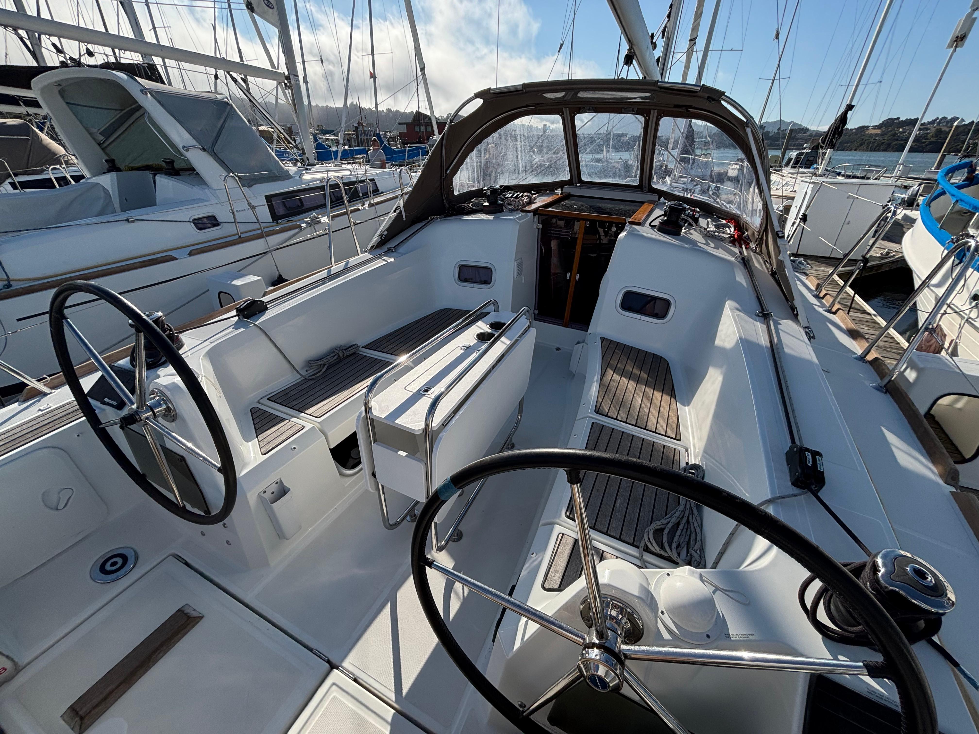 2021 Jeanneau Sun Odyssey 349 sailboat cockpit with dual steering wheels in marina.