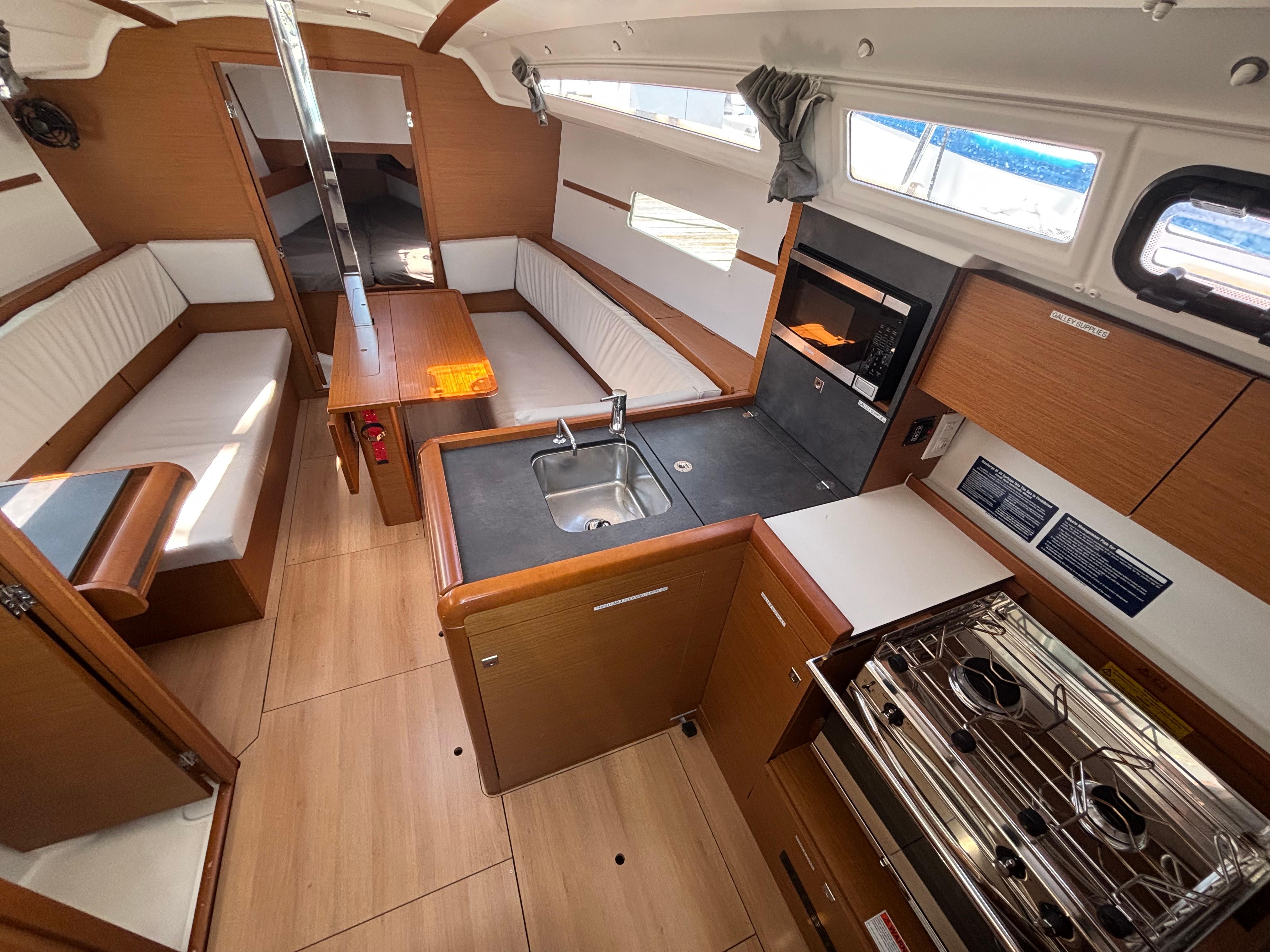 Interior of 2021 Jeanneau Sun Odyssey 349 sailboat with modern kitchen and seating area.