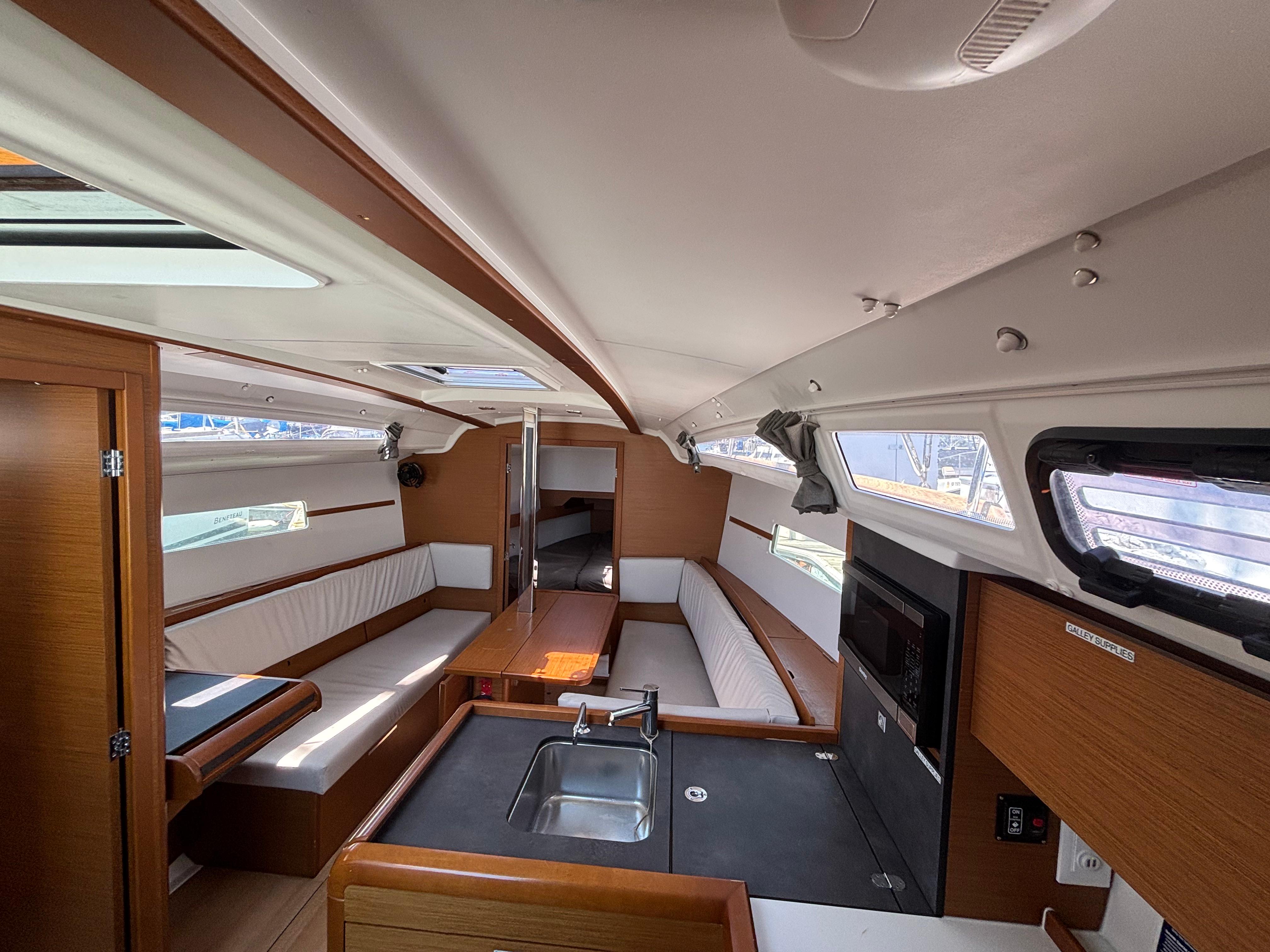 Interior of 2021 Jeanneau Sun Odyssey 349 sailboat, featuring modern kitchen and seating area.