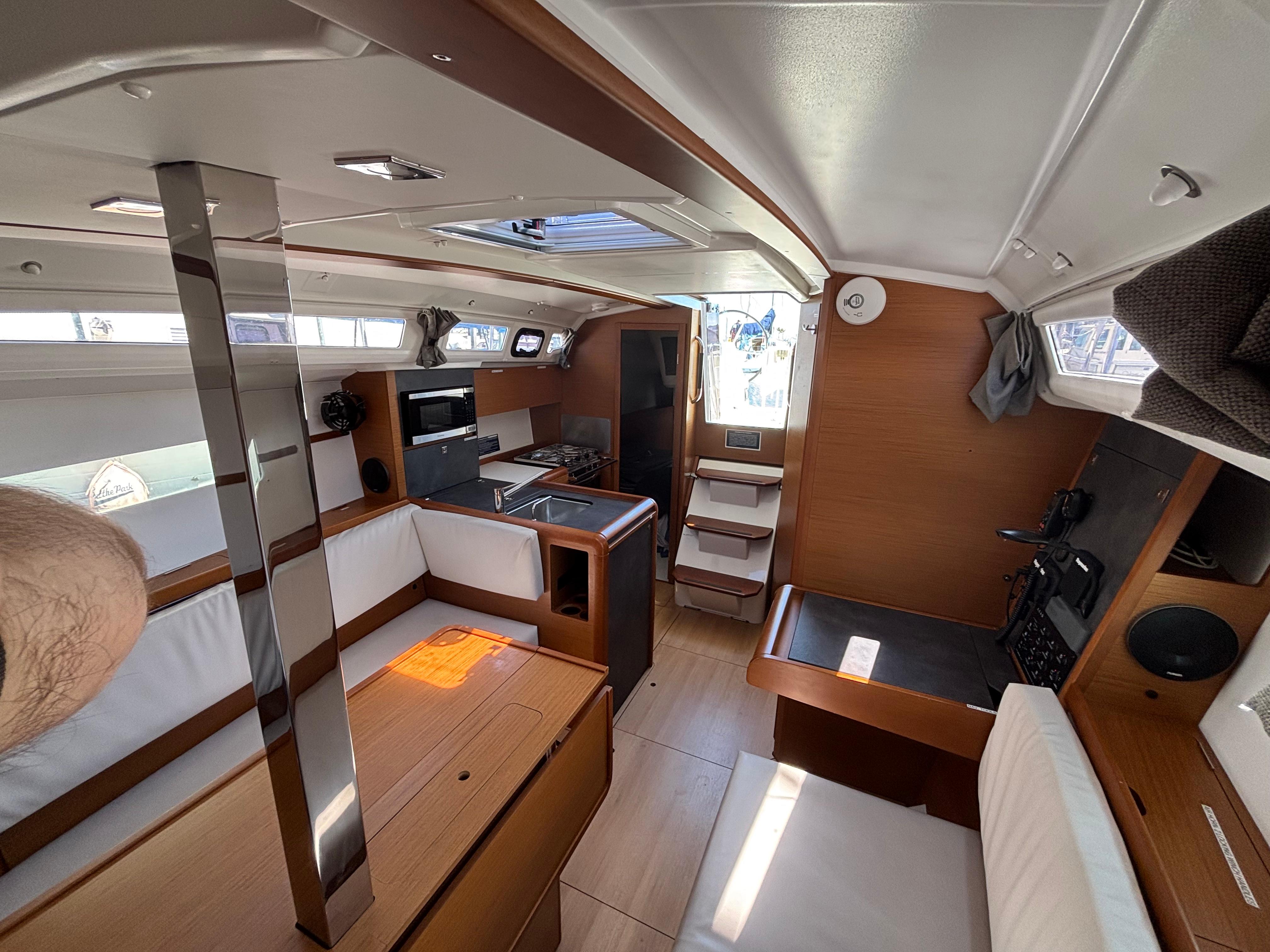 Interior of 2021 Jeanneau Sun Odyssey 349 sailboat, featuring modern wood finish and seating area.
