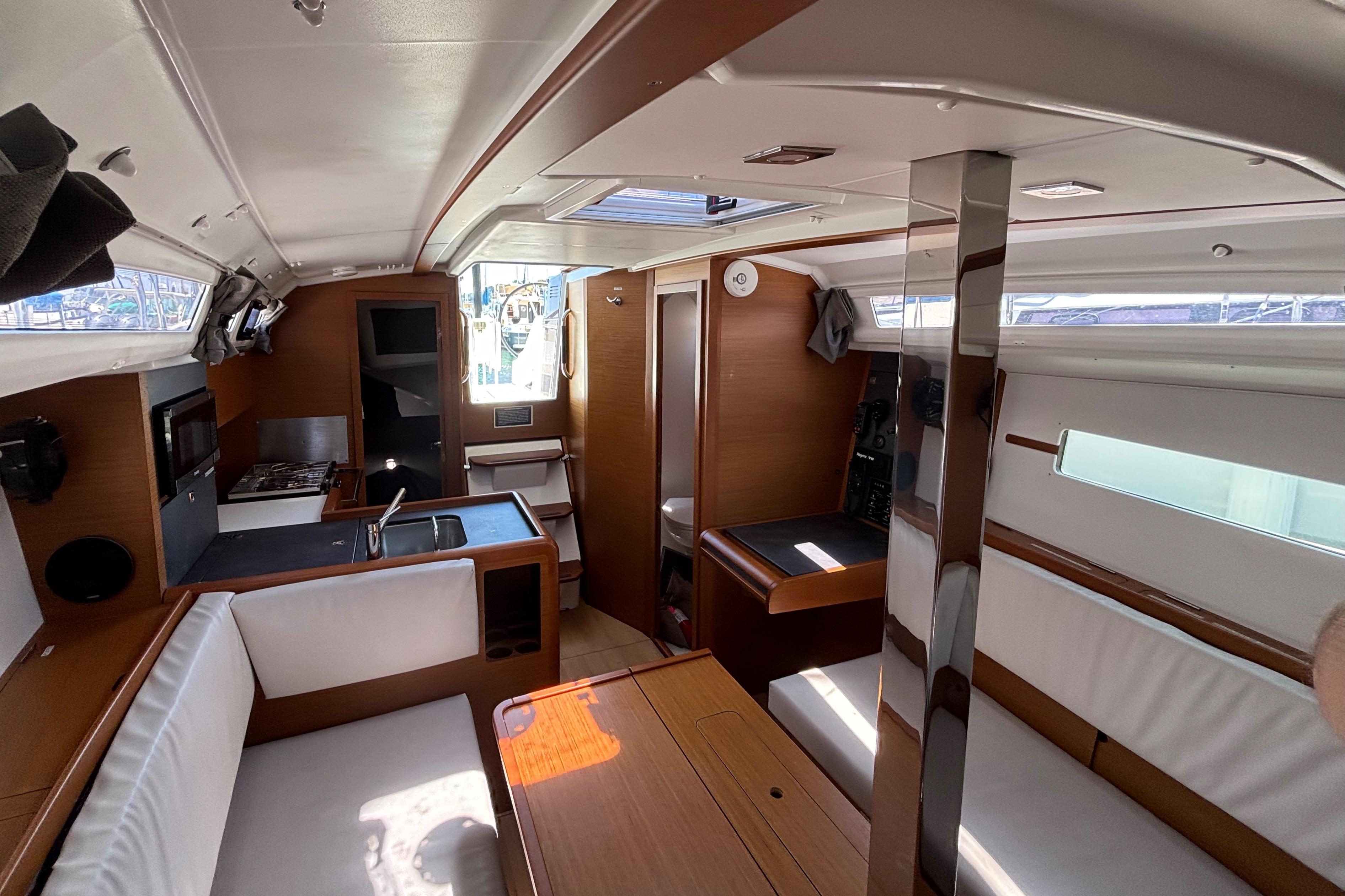 Interior of 2021 Jeanneau Sun Odyssey 349 sailboat, featuring modern kitchen and seating area.