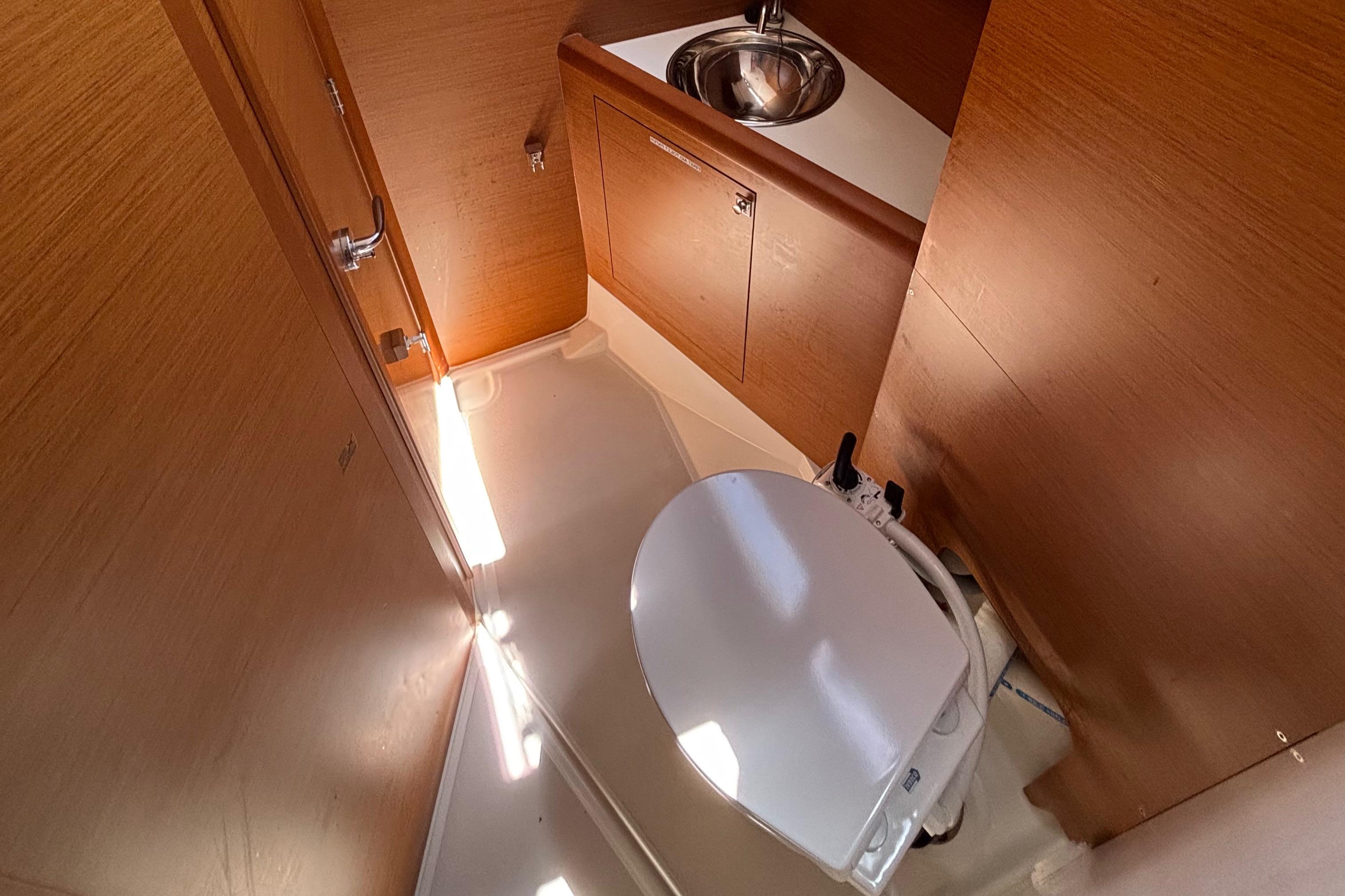 Interior of 2021 Jeanneau Sun Odyssey 349 yacht bathroom with sink and toilet.