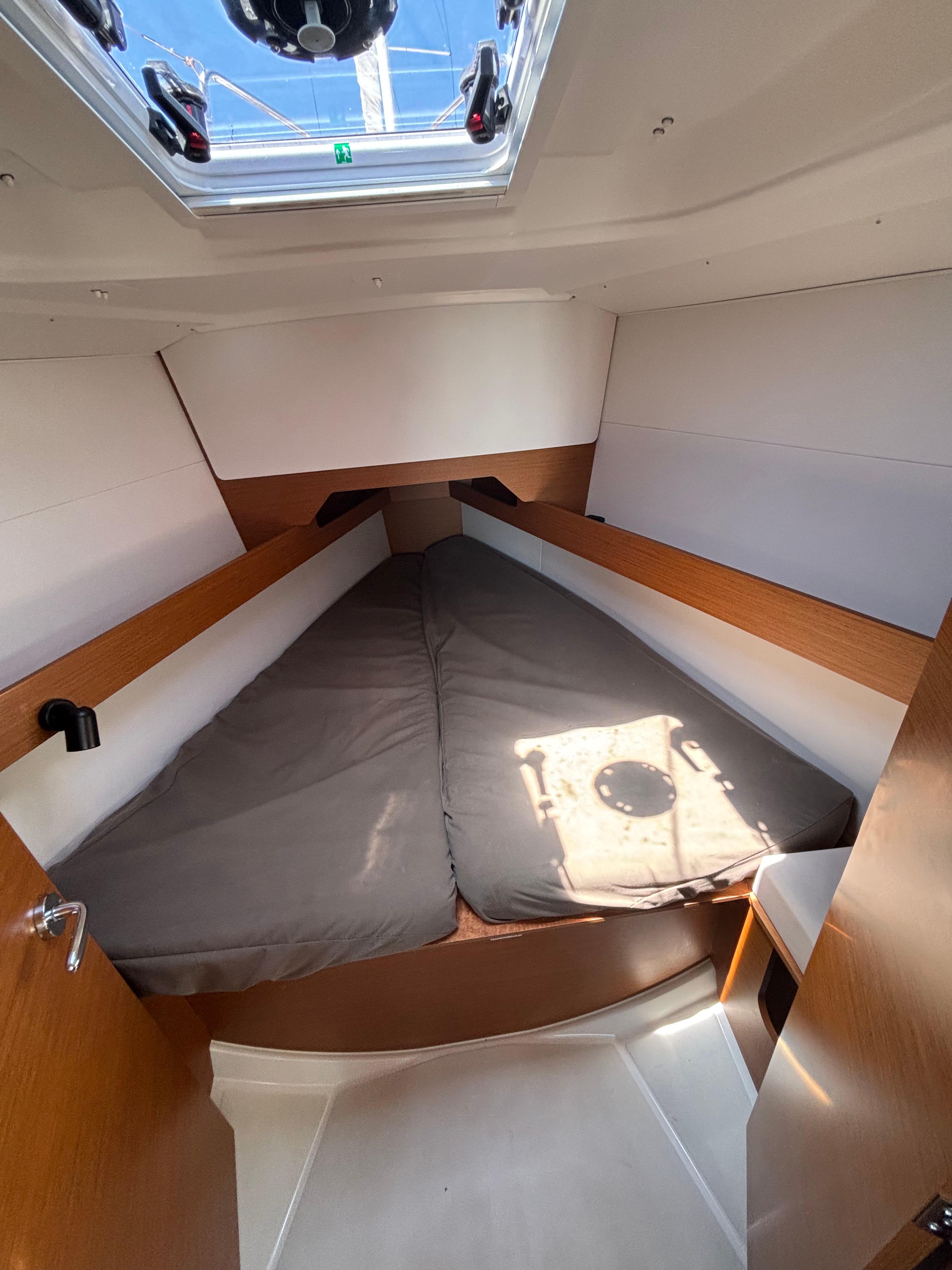 Cabin interior of 2021 Jeanneau Sun Odyssey 349 sailboat with skylight and cozy bedding.