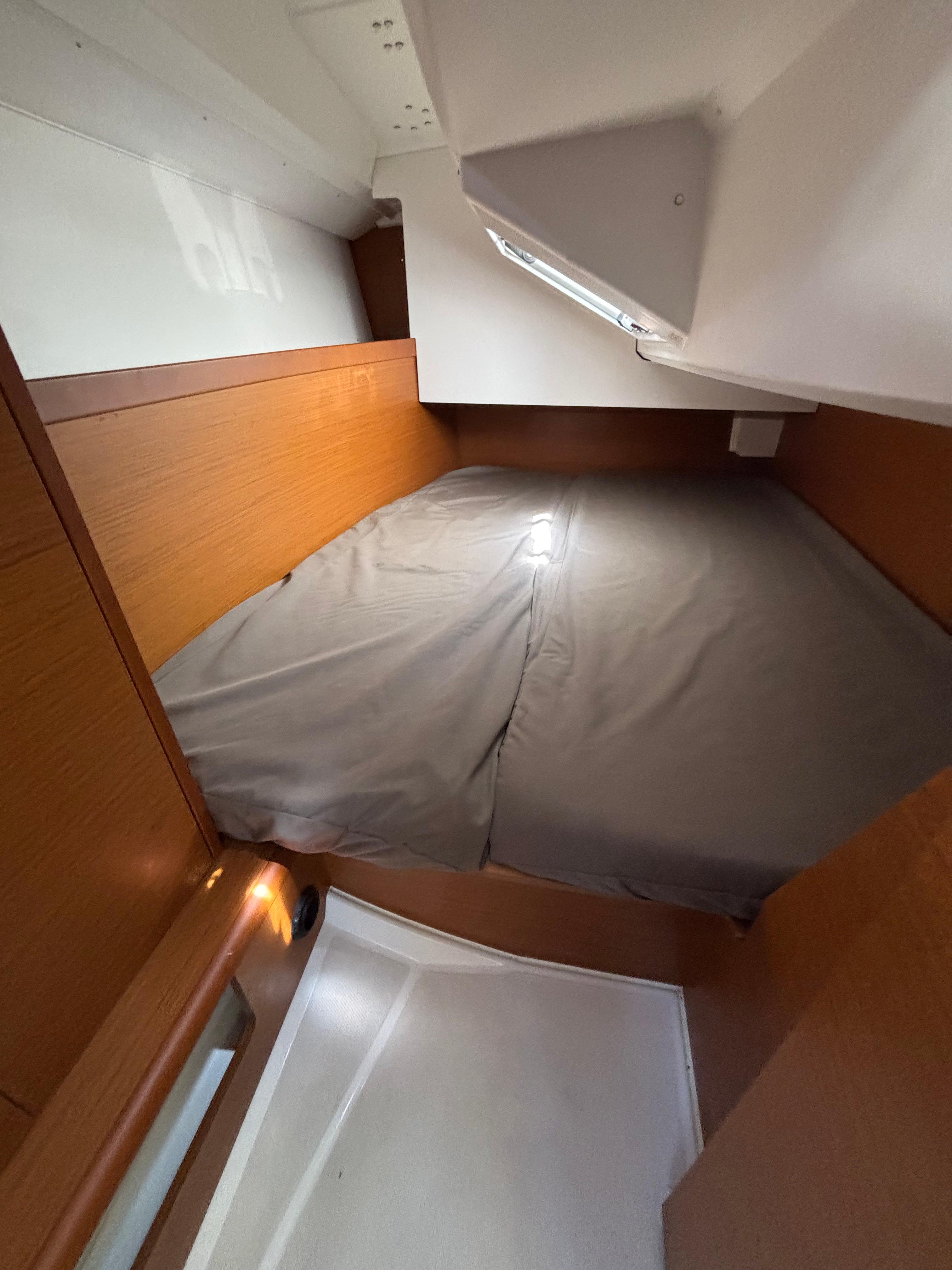 Cozy cabin interior of 2021 Jeanneau Sun Odyssey 349 sailboat with wooden accents.