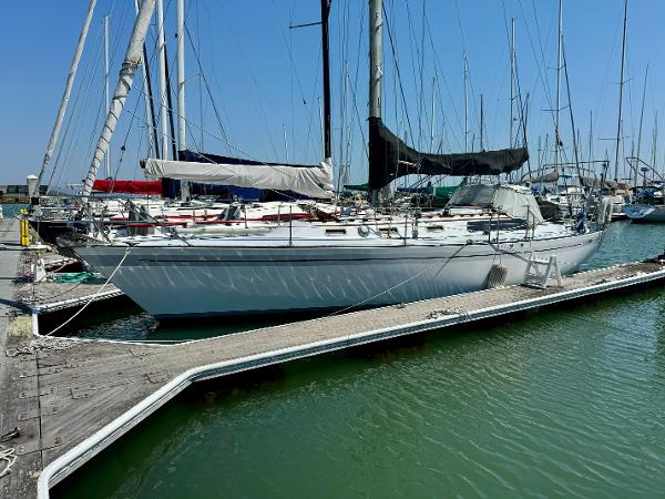 1979 Islander IP Peterson 40 sailboat docked at marina, clear blue sky.