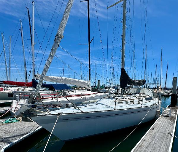 1979 Islander IP Peterson 40 sailboat docked at marina under clear blue sky.