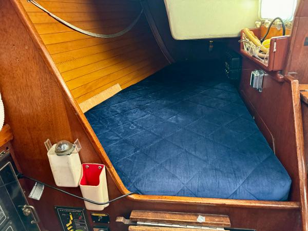 Cozy cabin interior of 1979 Islander IP Peterson 40 sailboat with blue bedding.