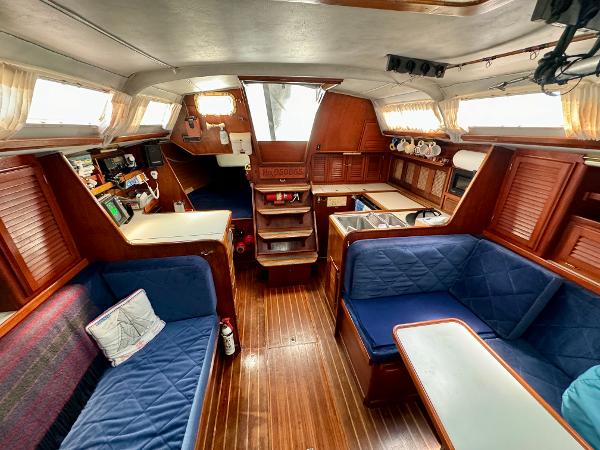 Interior of 1979 Islander IP Peterson 40 sailboat with wooden furnishings and blue seating.