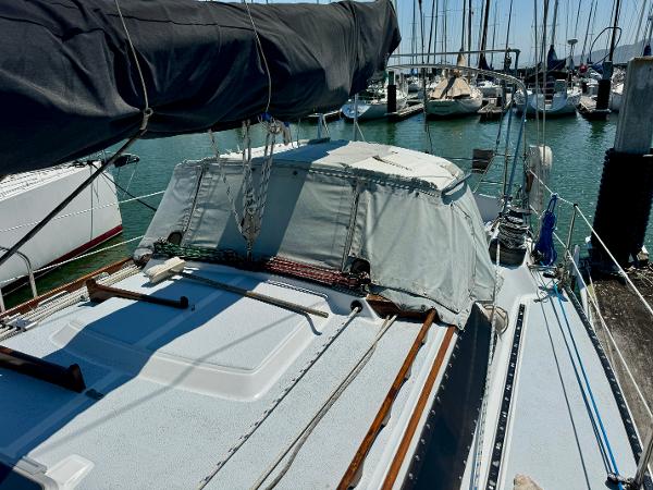 1979 Islander IP Peterson 40 sailboat docked in a marina, featuring a covered cockpit.