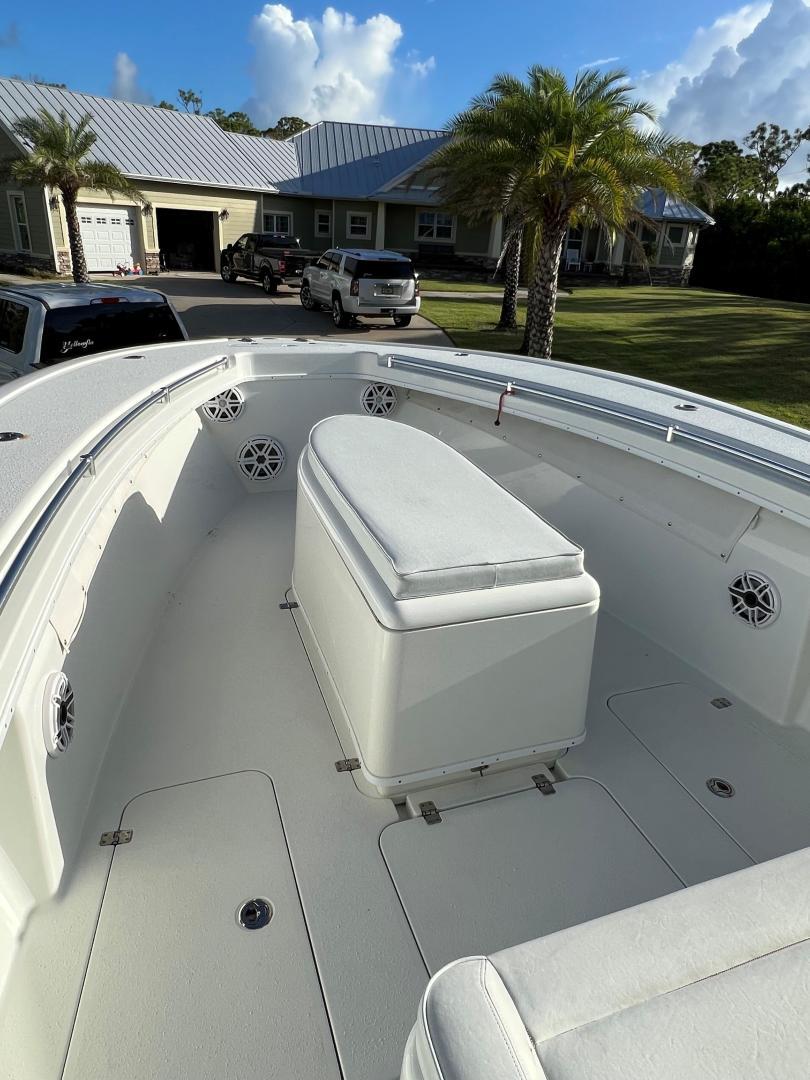 Yellowfin-32 Offshore 2016-32 Yellowfin FL-US-2016 Yellowfin 32 Offshore boat with spacious seating, parked near a house with palm trees.-9806474 | Thumbnail