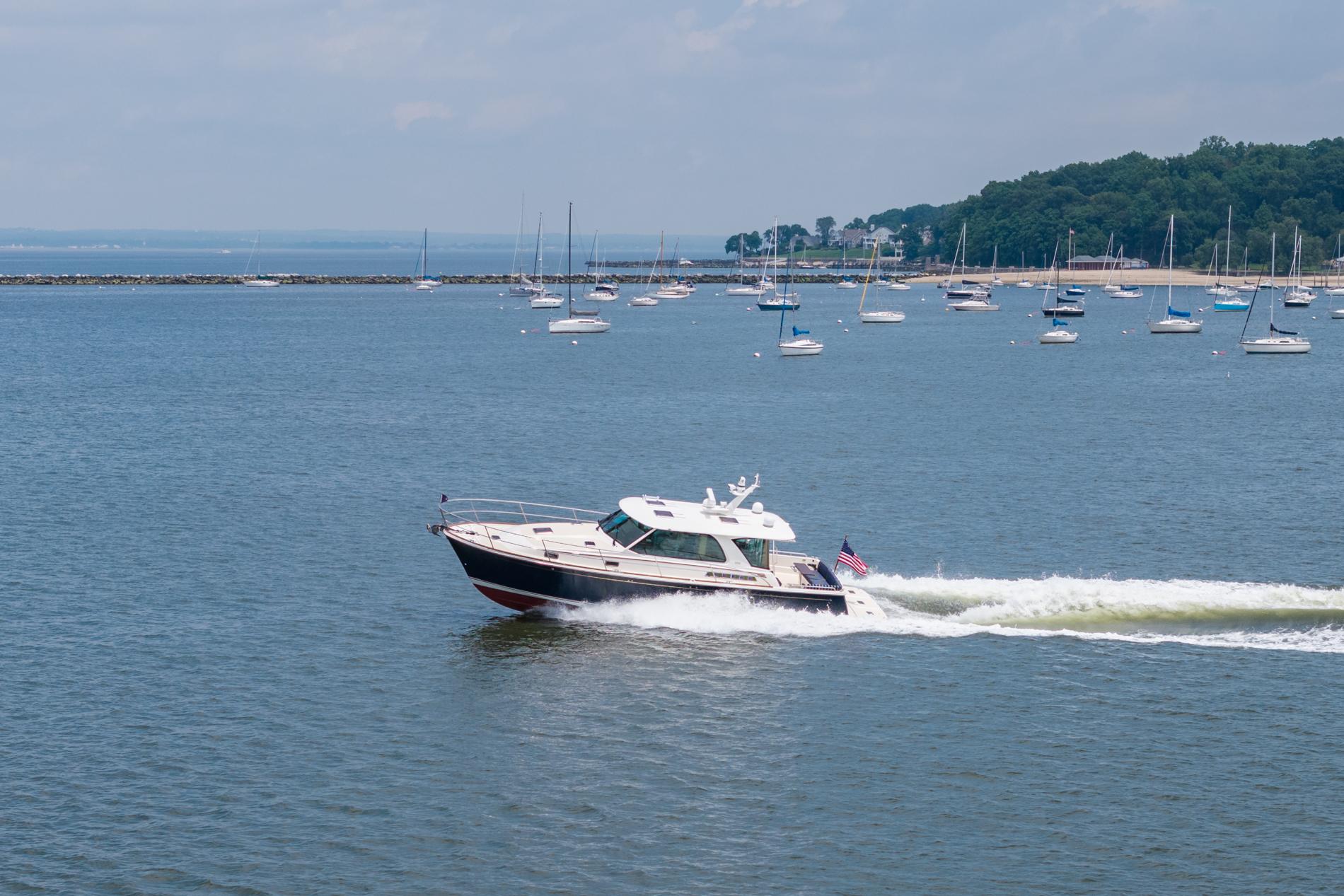 2024 Sabre 43 Salon Express cruising on a scenic bay with sailboats in the background.