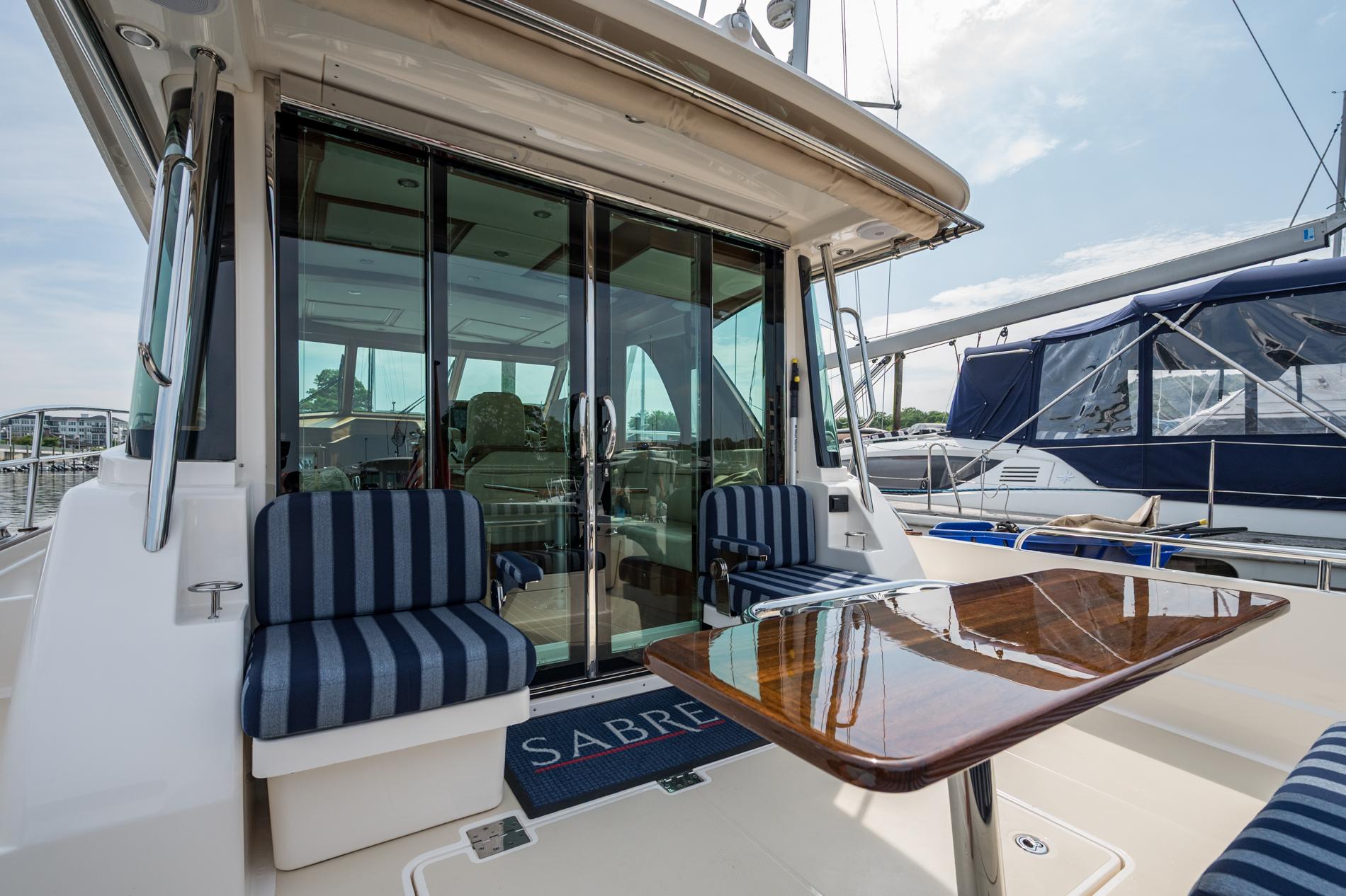 2024 Sabre 43 Salon Express yacht with striped seating and polished wood table.
