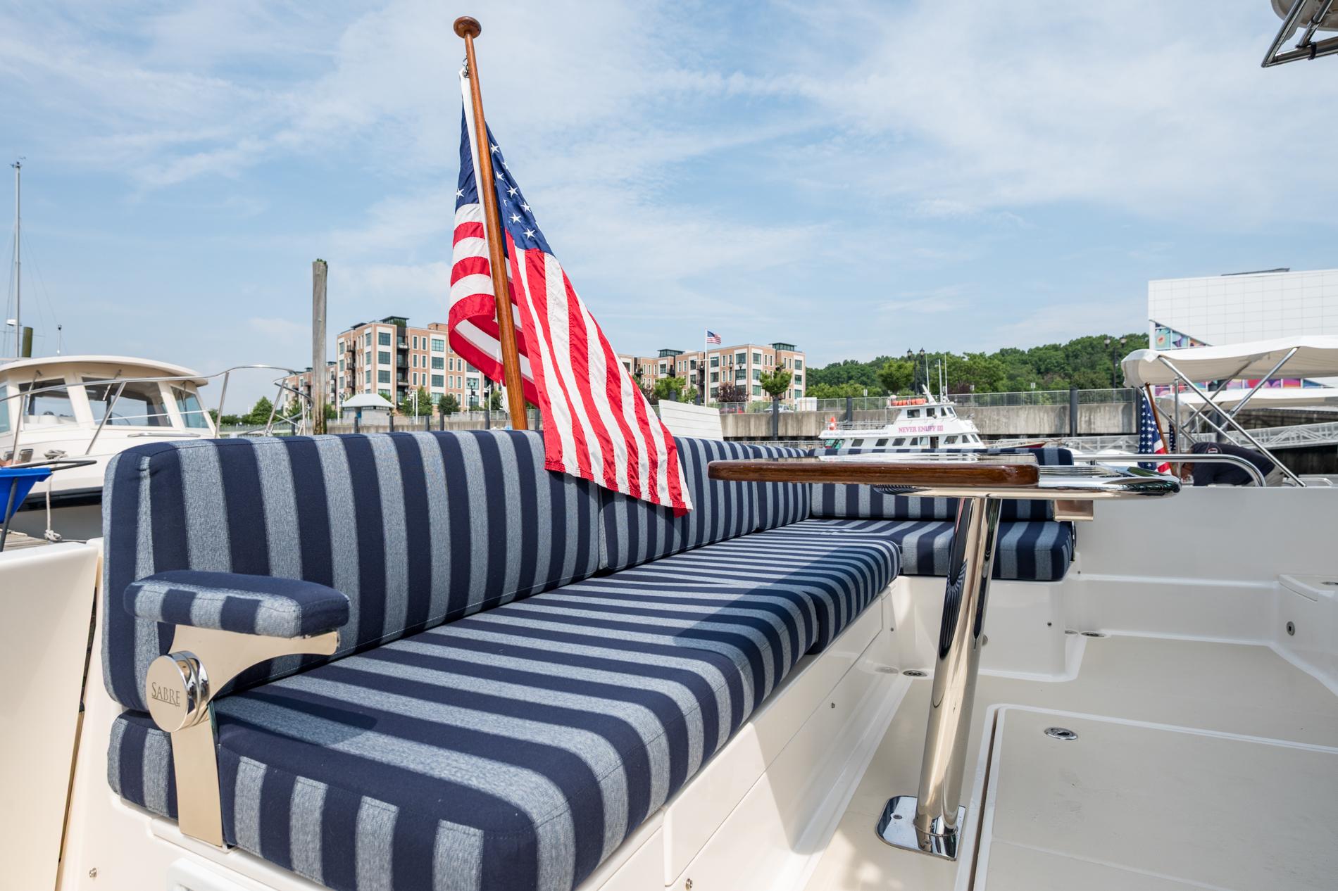 2024 Sabre 43 Salon Express yacht with striped seating and American flag at marina.