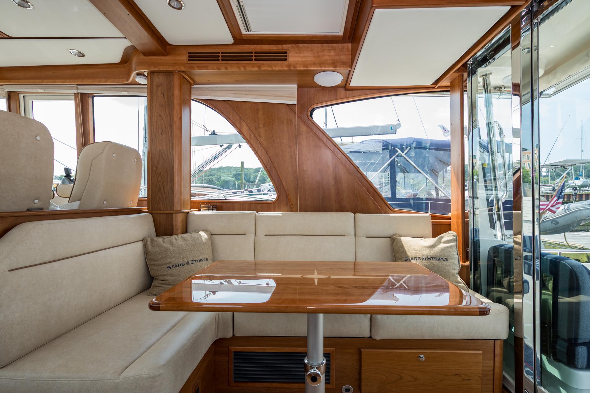 Luxurious interior of 2024 Sabre 43 Salon Express yacht with elegant wood and plush seating.