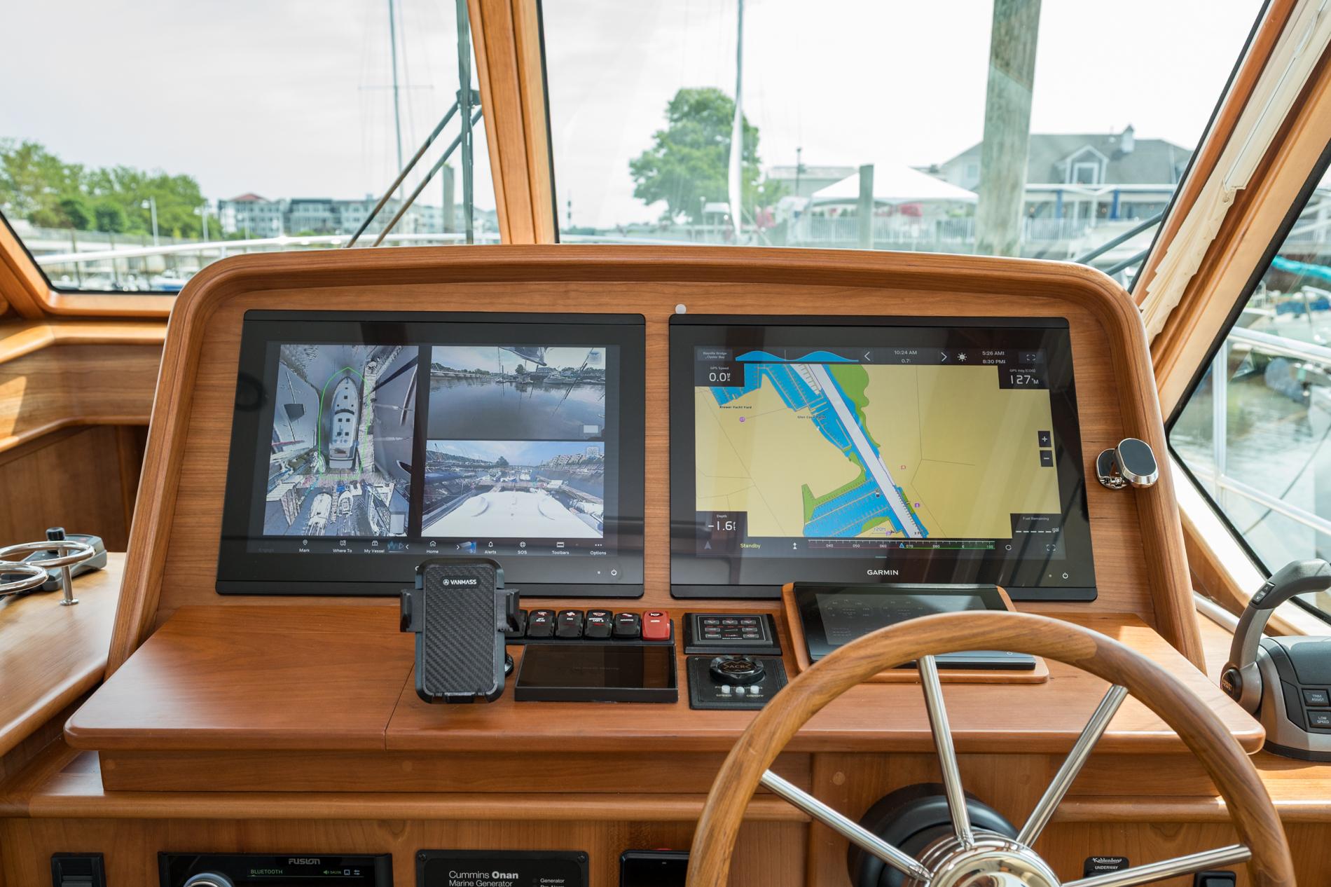 2024 Sabre 43 Salon Express helm with dual navigation screens and wooden steering wheel.