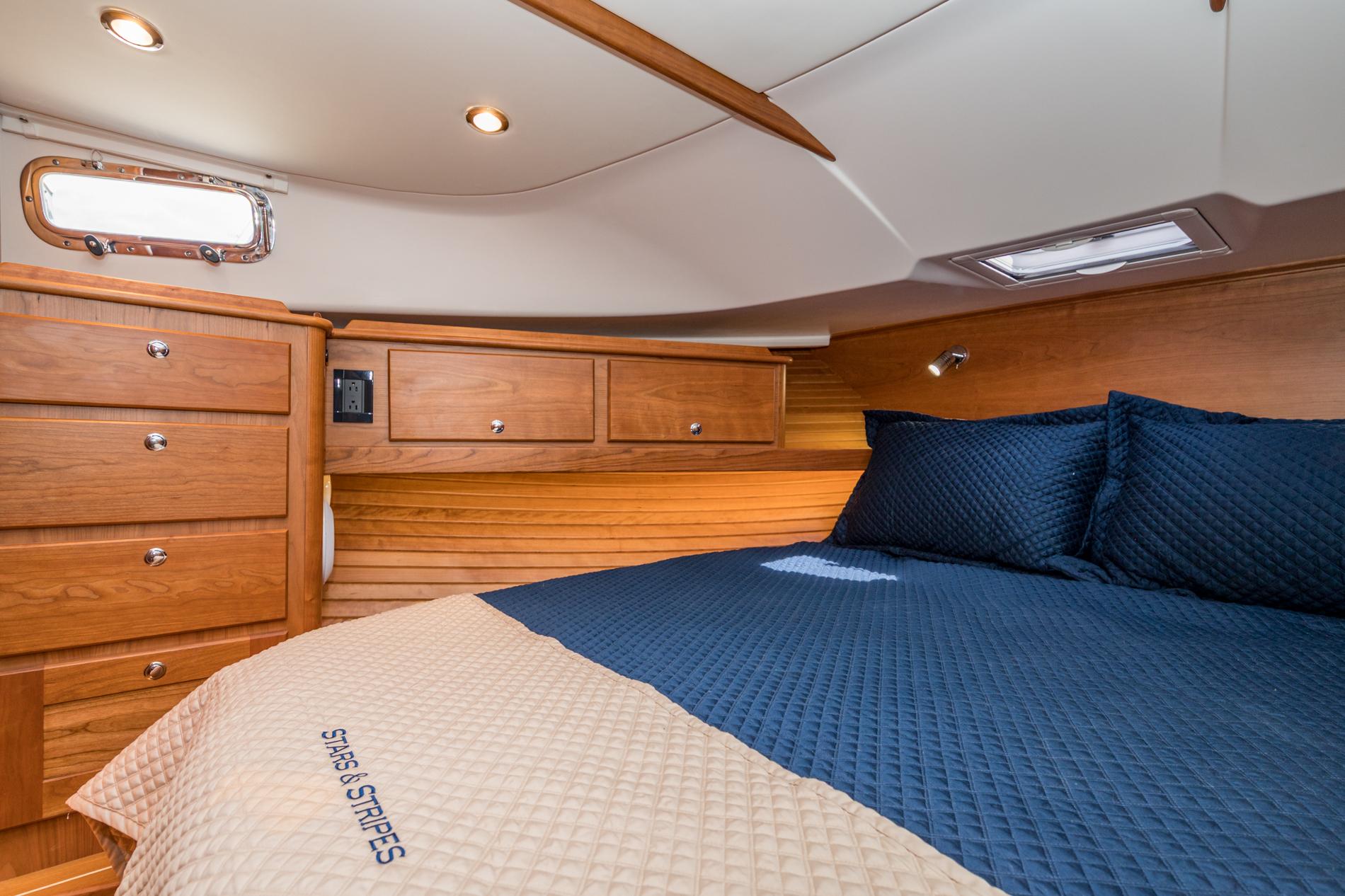 Luxurious cabin interior of 2024 Sabre 43 Salon Express yacht with wood finish and cozy bedding.