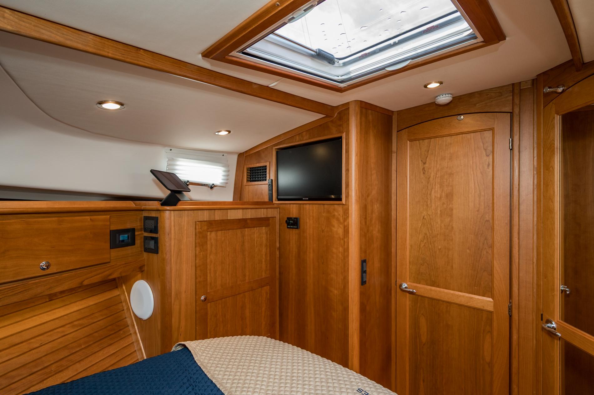 2024 Sabre 43 Salon Express interior with wood finish, skylight, and TV.