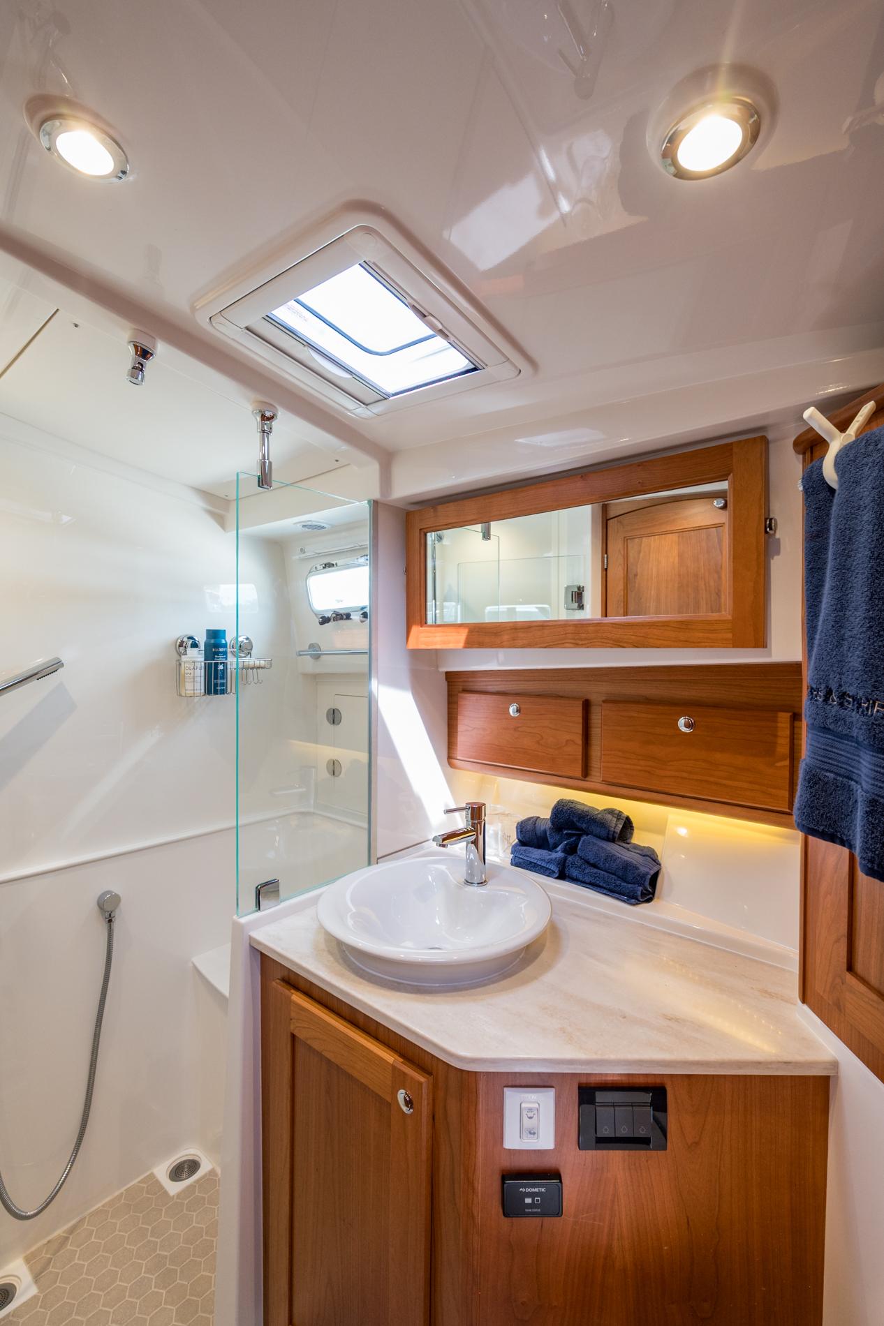 2024 Sabre 43 Salon Express bathroom with modern fixtures and wooden cabinetry.