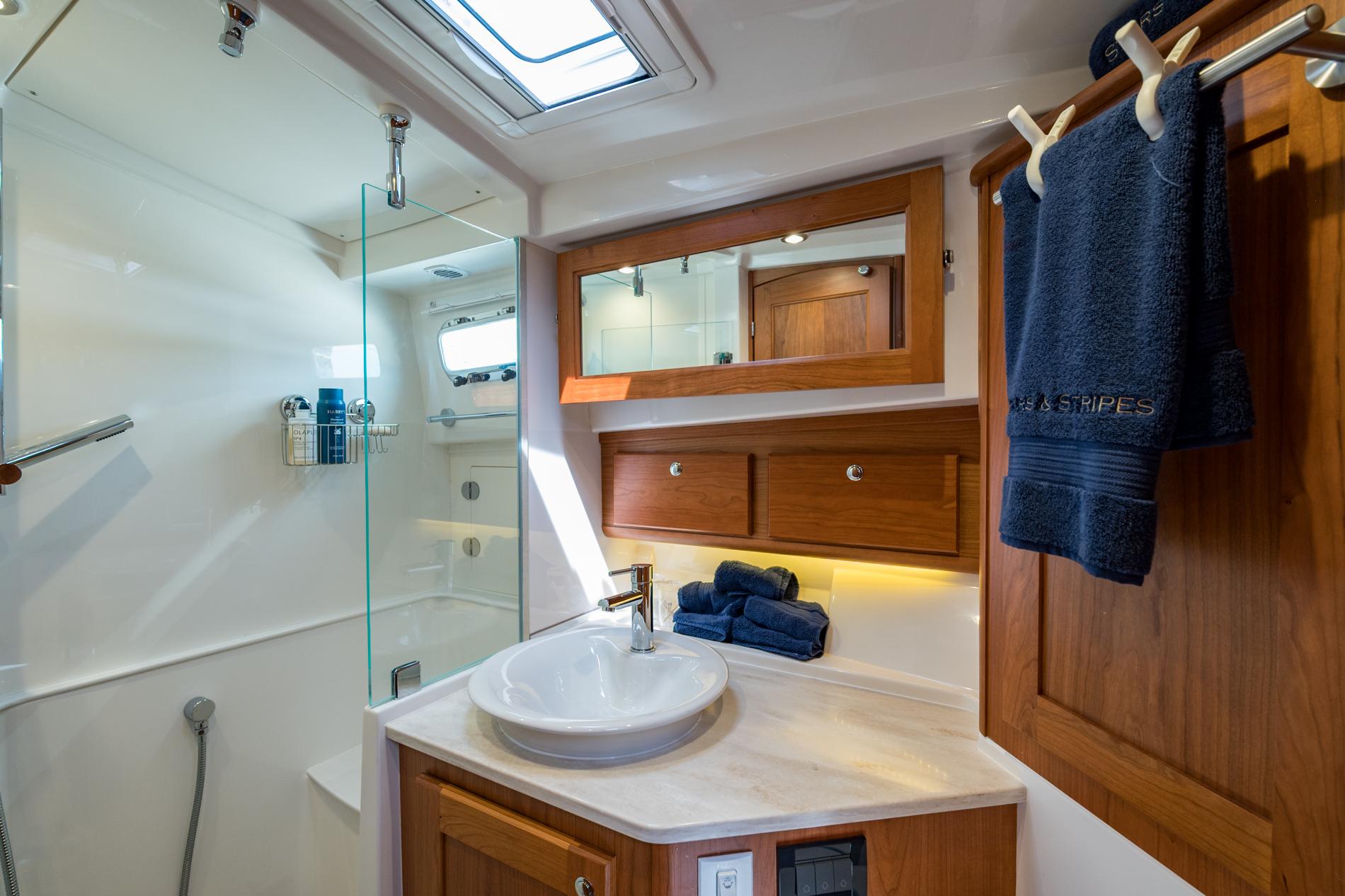 Luxurious bathroom in 2024 Sabre 43 Salon Express yacht with modern fixtures and wooden cabinetry.