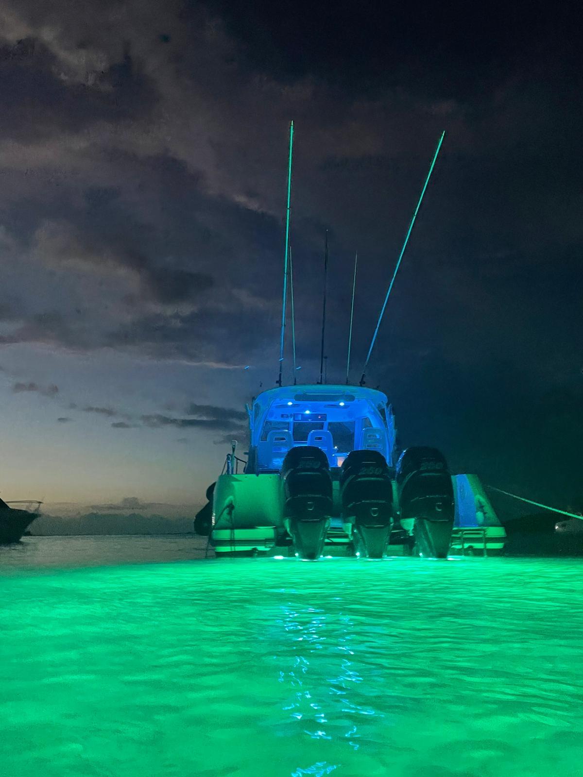 Boston Whaler-345 Conquest 2012 -PR-Boston Whaler 345 Conquest 2012 boat with glowing green underwater lights at night.-9446483 | Thumbnail