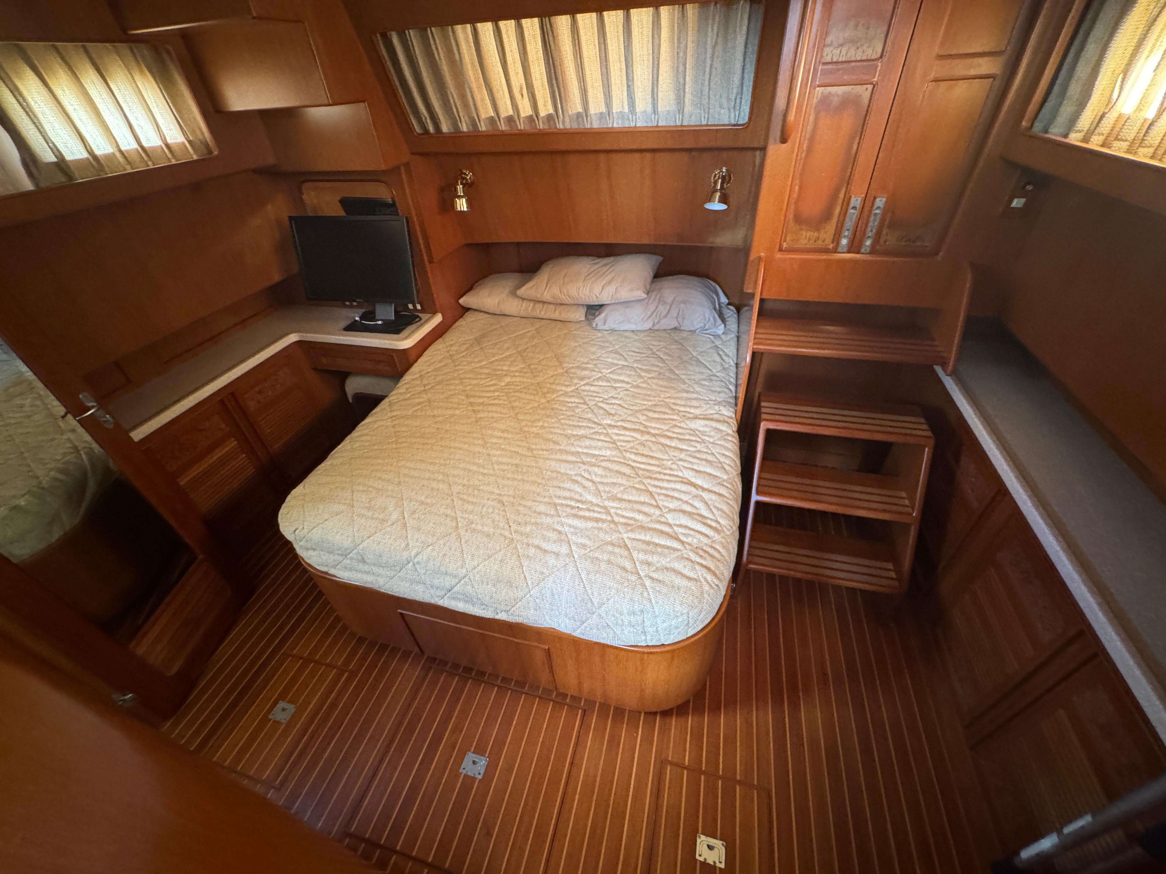 Cozy cabin interior of 2003 President Performance Trawler with bed and wooden furnishings.