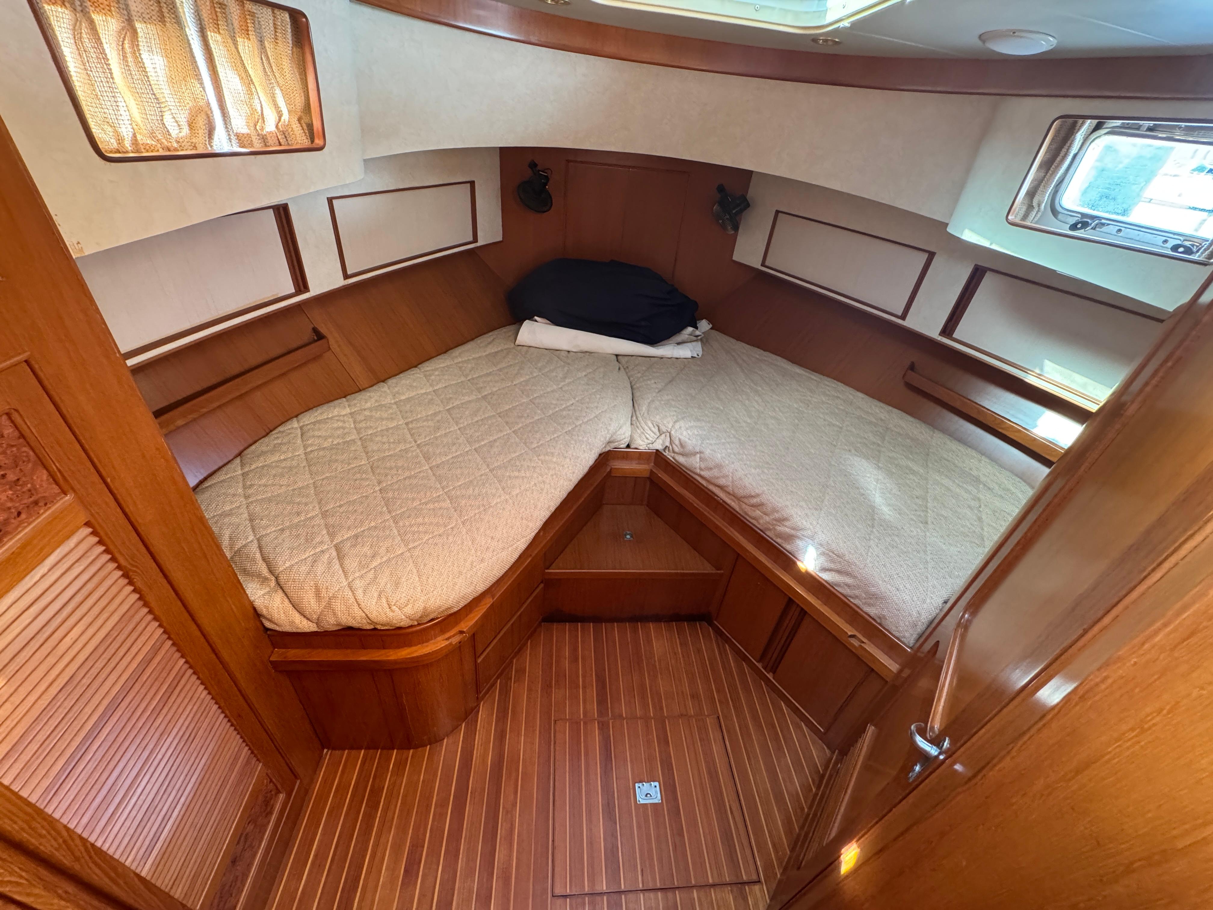 Cozy cabin interior of 2003 President Performance Trawler with wood paneling and comfortable bedding.