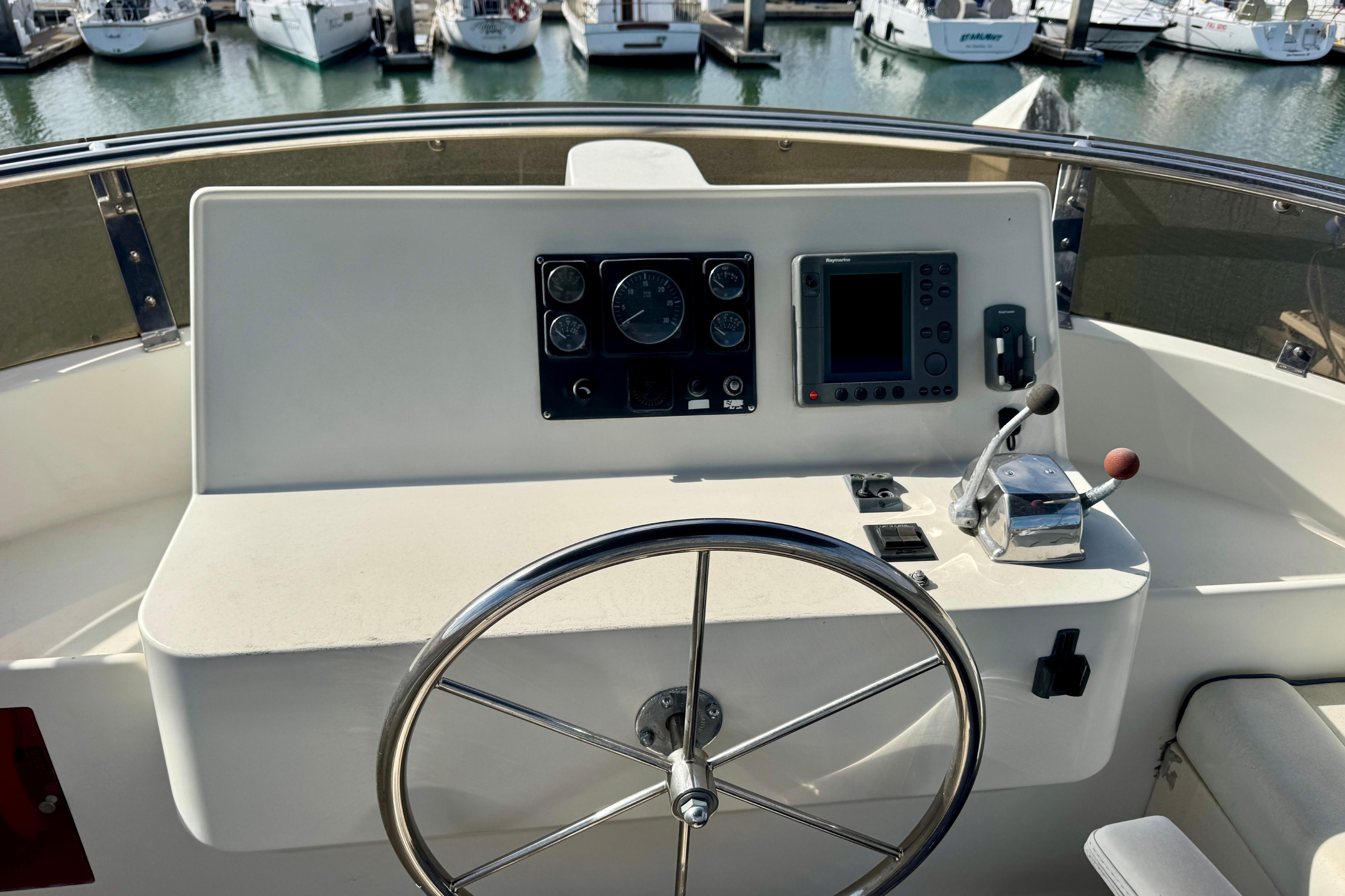 Helm of 2003 President Performance Trawler with steering wheel and navigation controls.