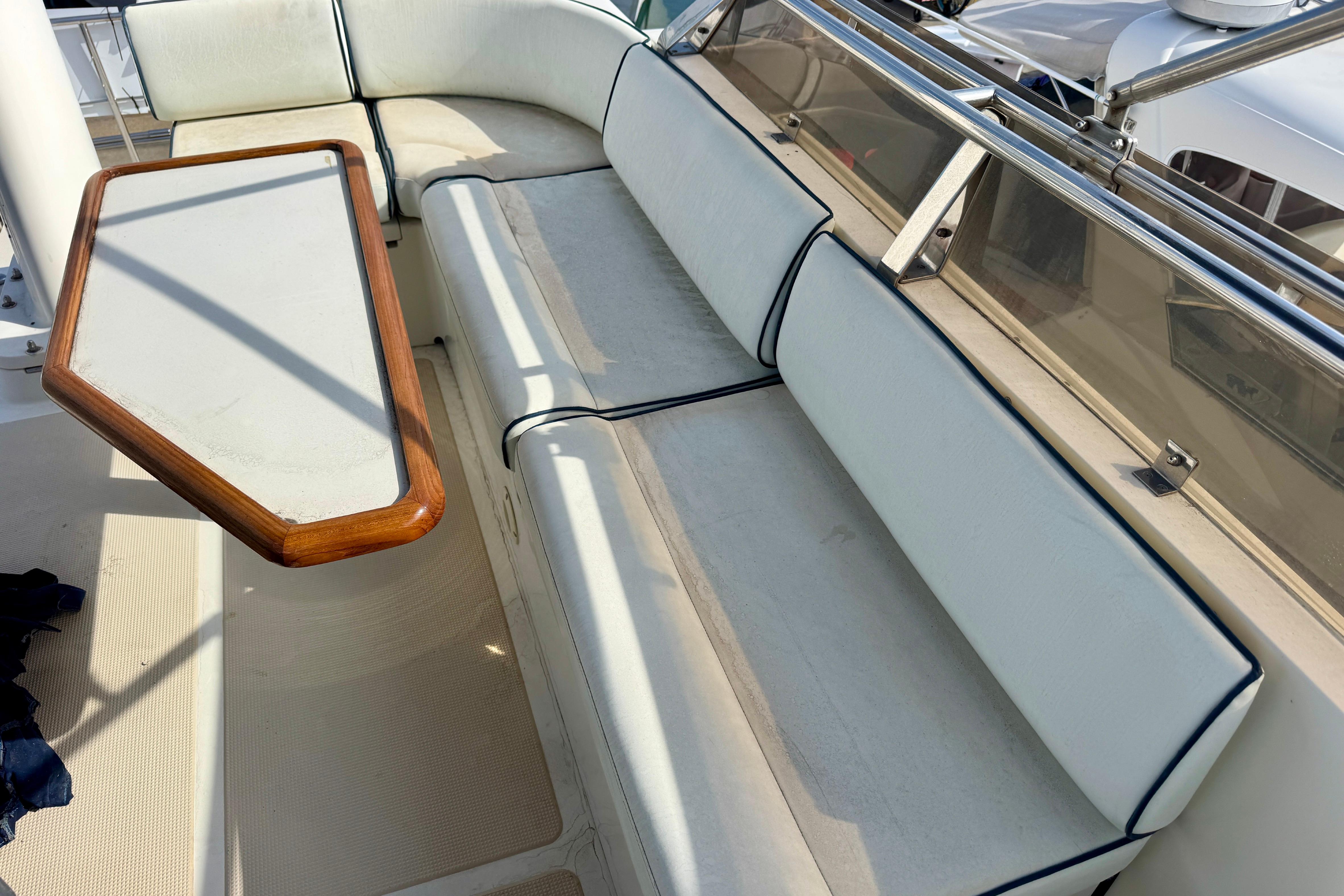 2003 President Performance Trawler seating area with cushioned benches and a wooden table.