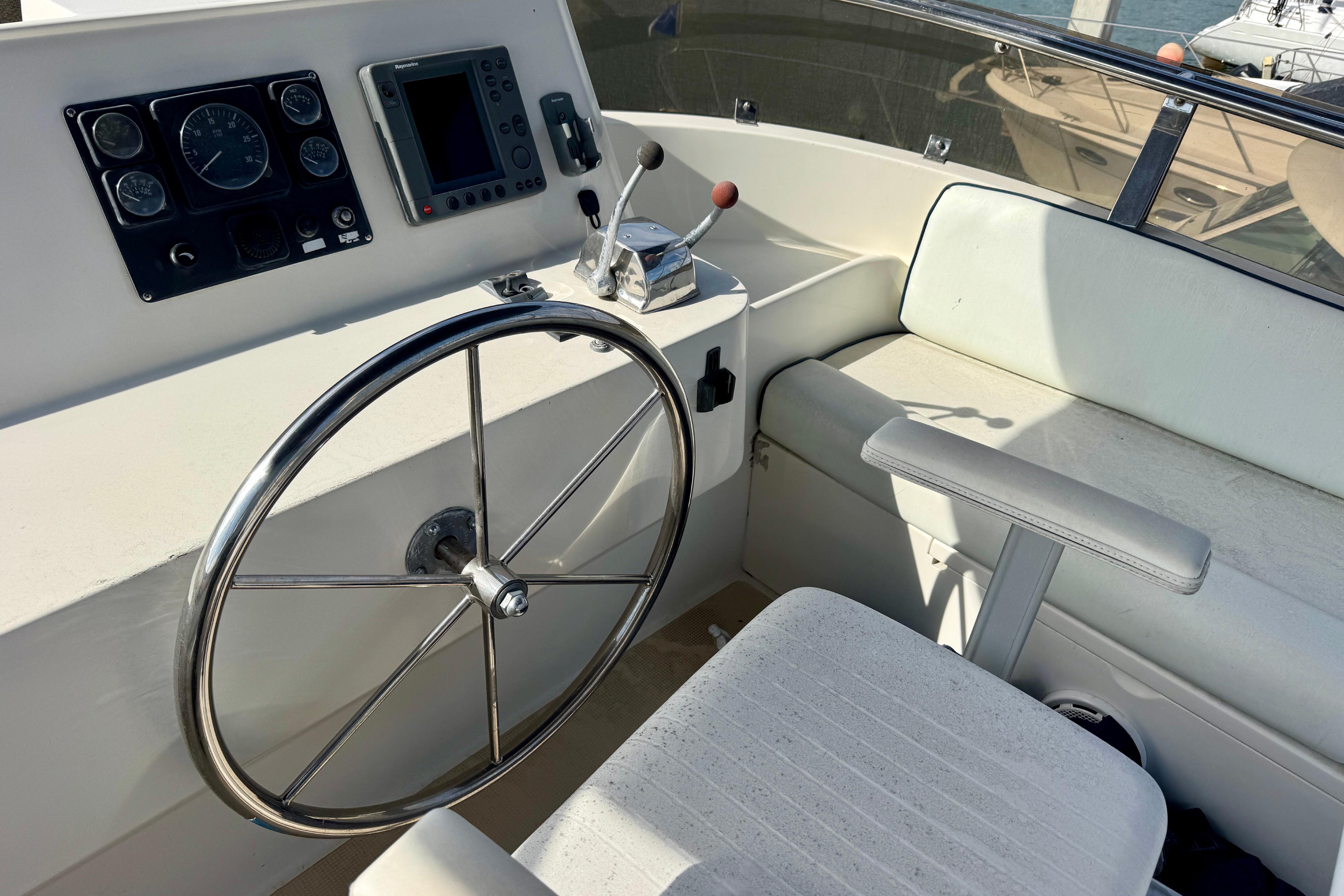 2003 President Performance Trawler helm with steering wheel and navigation controls.
