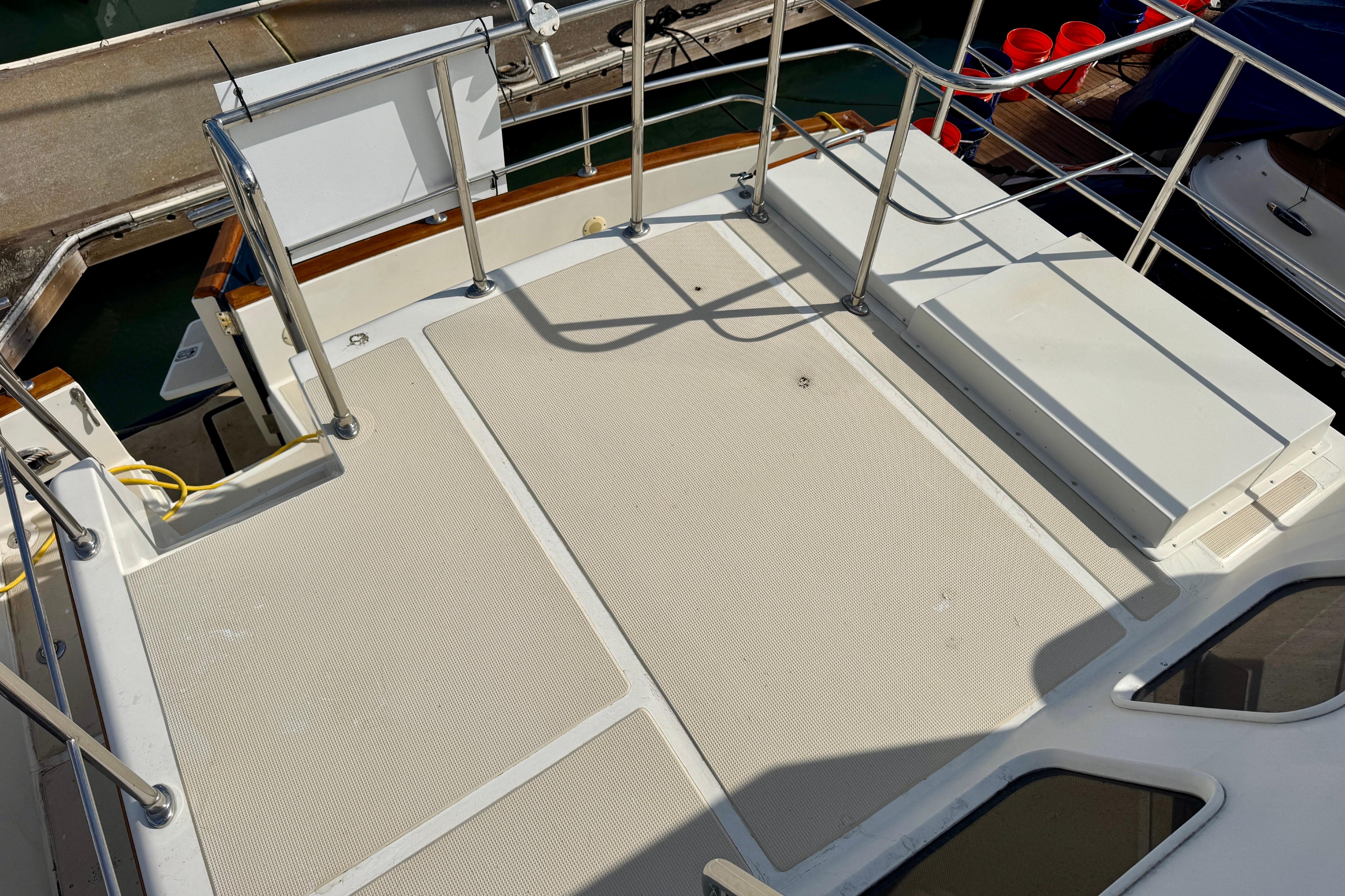 2003 President Performance Trawler deck with railing and storage compartments.