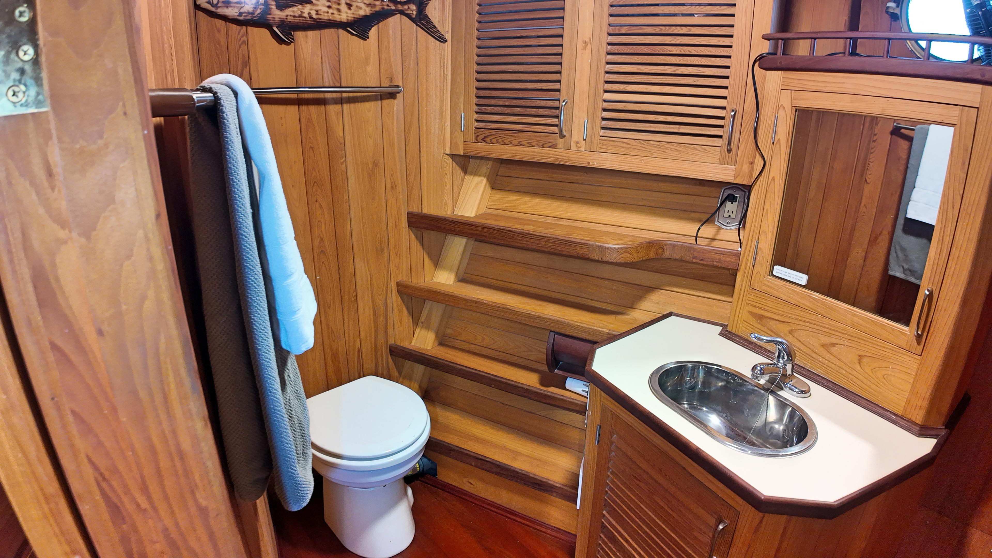 Custom-Holland Marine 50 Custom Trawler 1993-La Vita Marina SC-US-Wood-paneled bathroom in 1993 Holland Marine 50 Custom Trawler with sink, toilet, and mirror.-9816492 | Thumbnail