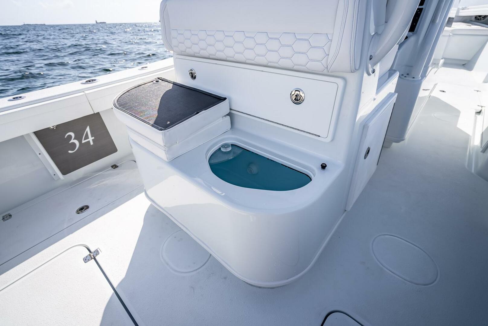 Yellowfin-34 Offshore 2025-34 Offshore FL-US-2025 Yellowfin 34 Offshore boat interior with storage and seating, ocean in background.-9806499 | Thumbnail