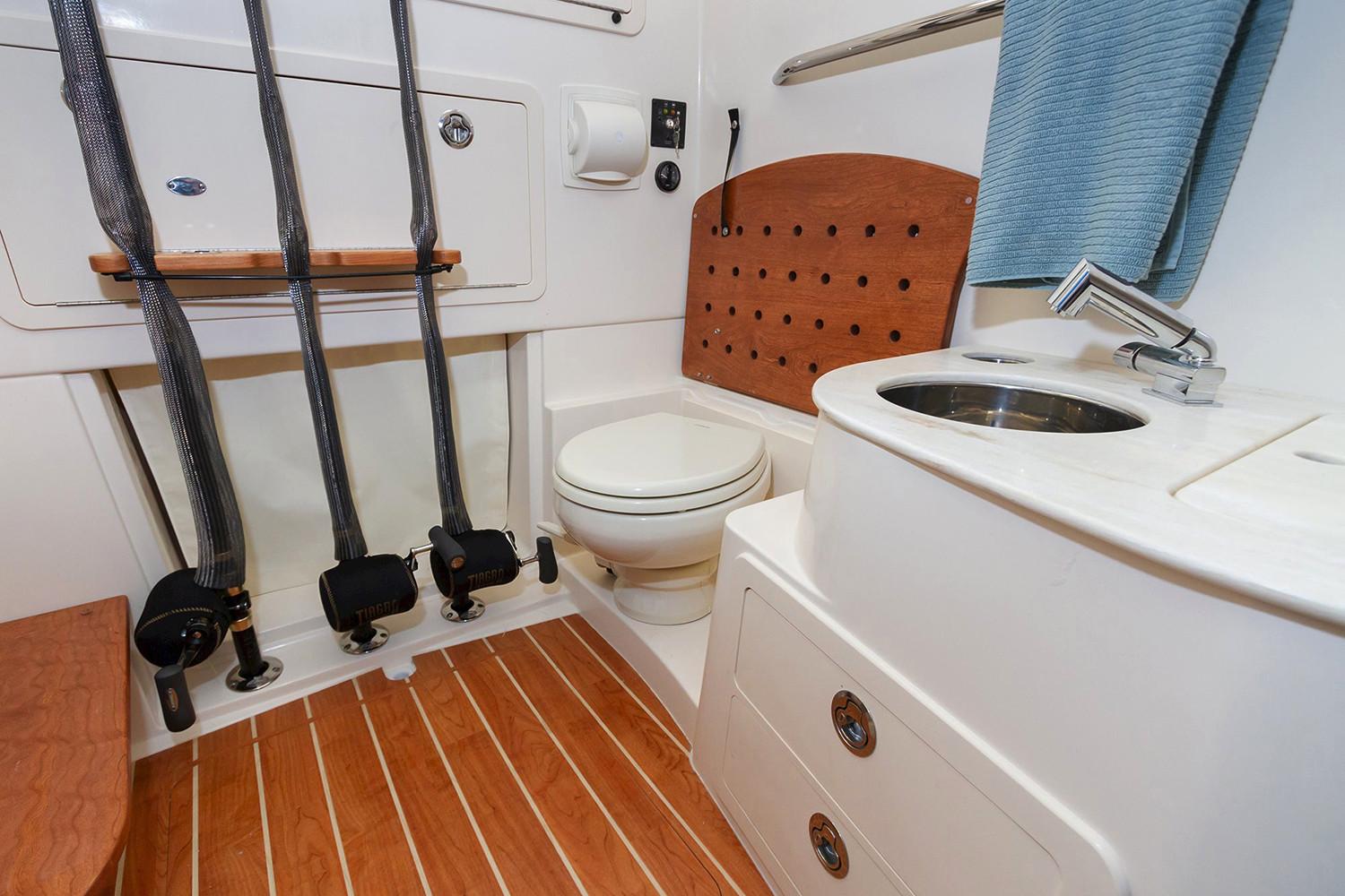 Manufacturer Provided Image: 2020 Grady-White Canyon 336 boat bathroom with toilet, sink, and rod holders.